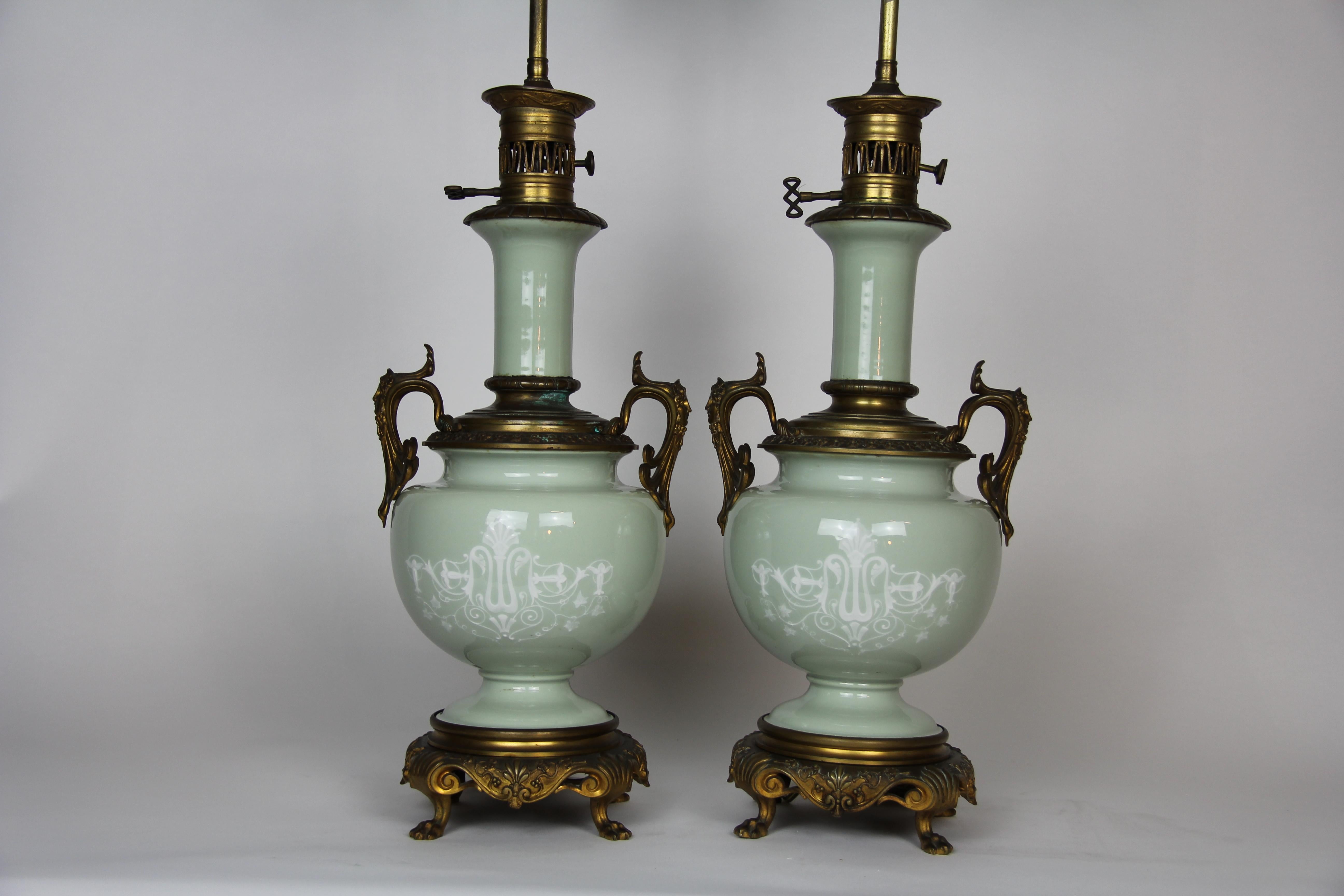 Una bella coppia di lampade francesi in stile Luigi XVI con montatura in bronzo dorato e doppio lato in Pate Sur Pate Celadon. Ogni lampada è splendidamente disegnata con figure pate sur pate di fanciulle e putti. Sul retro di ogni lampada sono