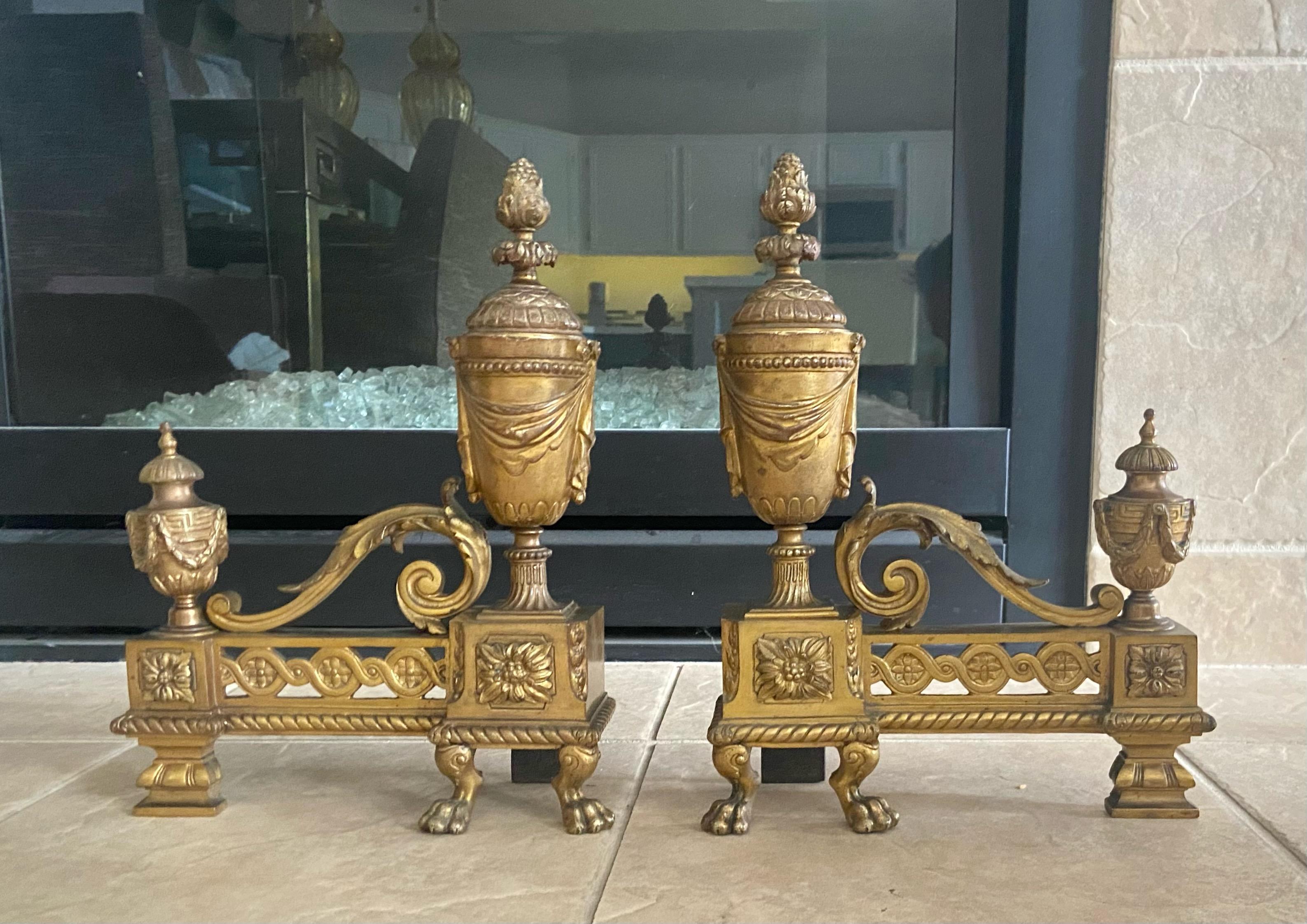 Pair of 19th century French Louis XVI neo-classical style gilt bronze chenets or andirions. 
Finely detailed including urn draped forms and lion paws.