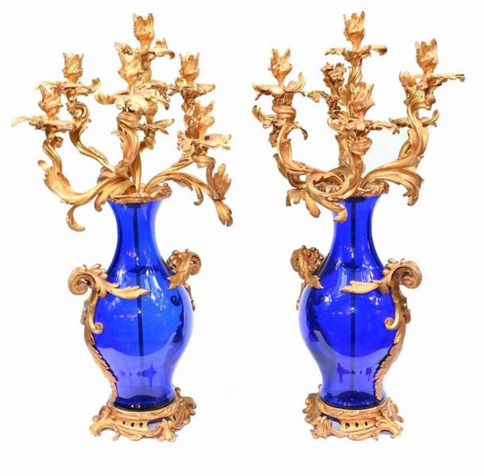 Eye catching pair of French gilt candelabras mounted on blue glass urns
The gilt is so well cast, very intricate and with a quality patina
The look is very rococo with the flowing swirls of the candelabra branches and the floral handles
We date