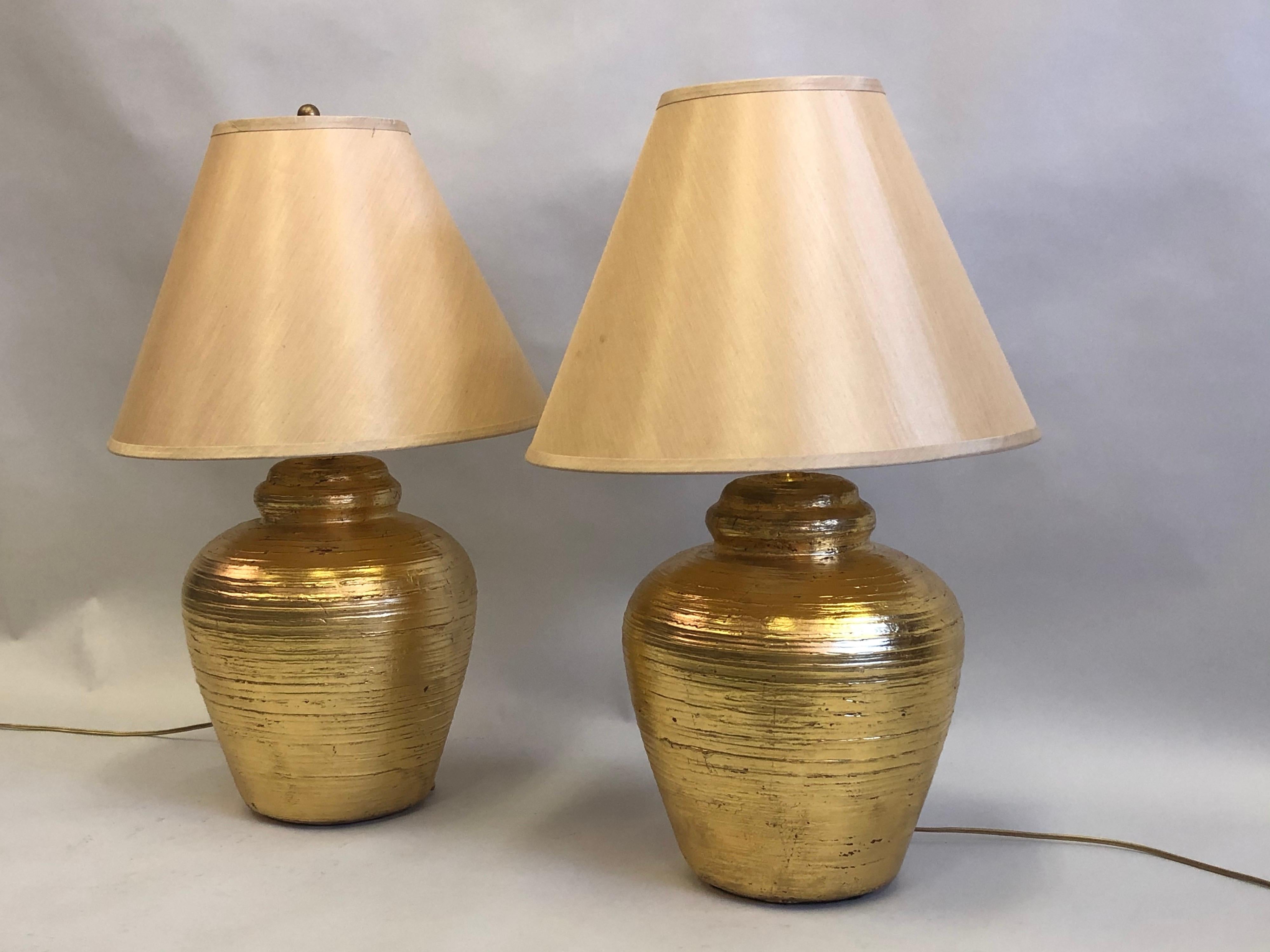 Pair of French Mid-Century Modern, Artisan made, table lamps in terracotta in the style of Alberto and Diego Giacometti for Jean Michel Frank.

Timeless pieces, hand formed in terracotta and hand gilt reflecting the purity, simplicity and elegance