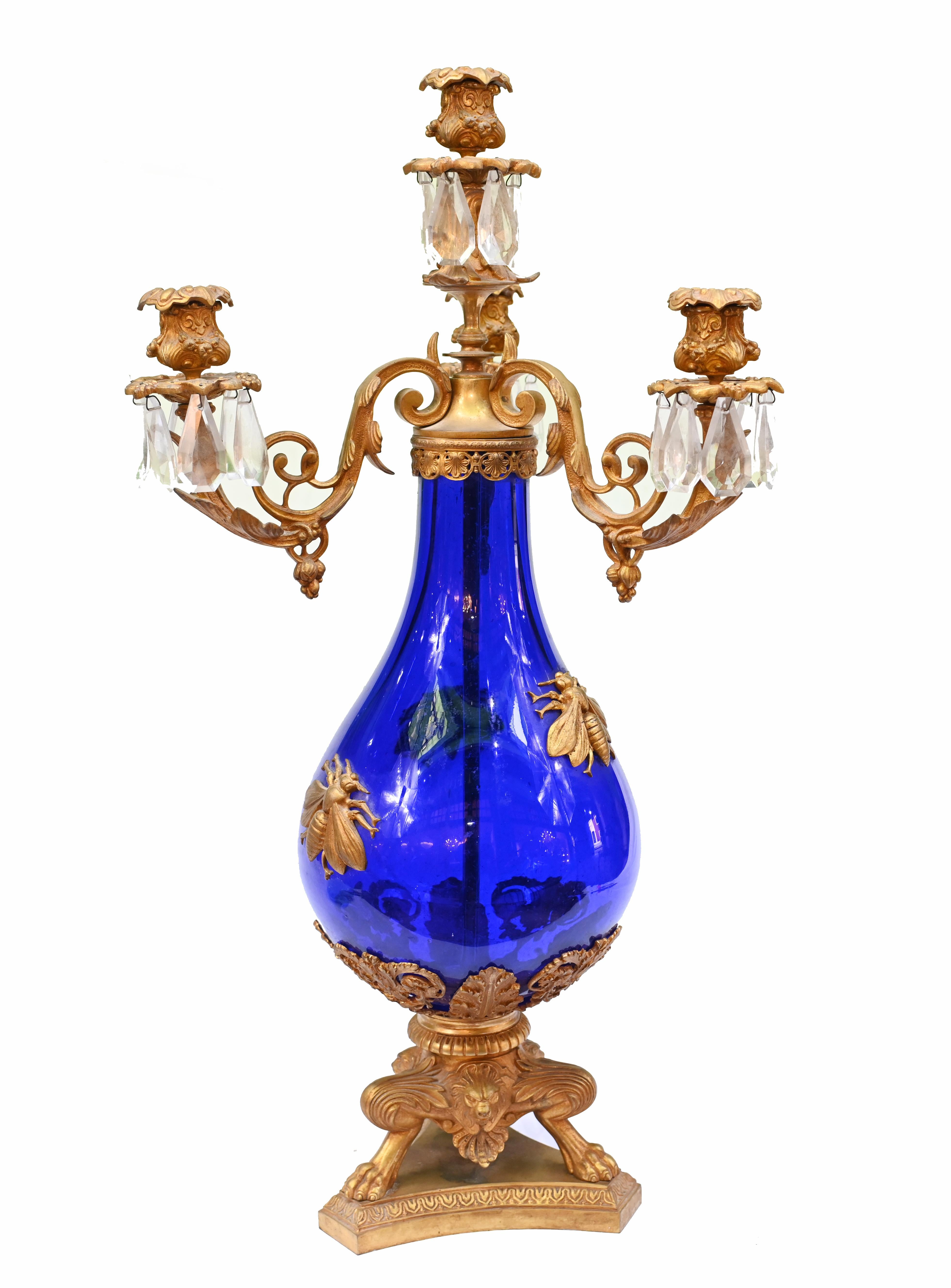 Great pair of antique French candelabras with gilt branches mounted on blue glass vases
Four branches to each urn
Love the quirky winged insect - hornet? - mounts on the glass
Base also distinctive with acanthus motifs and lions paw feet
Circa