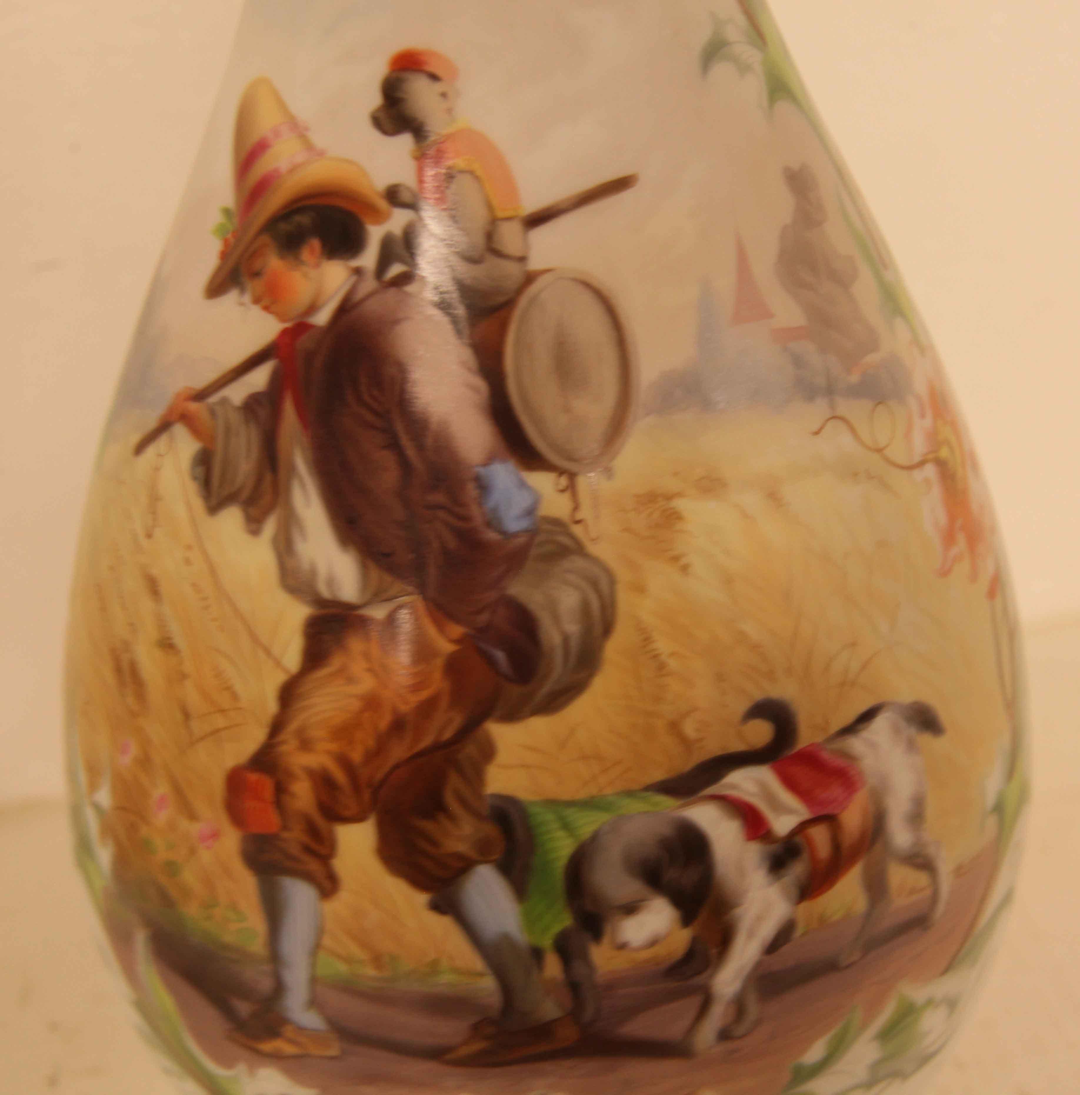 Pair of French tall glass vases,  each rim is gilded, one vase depicts a young boy and his dogs with a monkey on his back walking along an open trail, he has a stick in one hand and the other is in his pocket; the monkey appears to be sitting on a