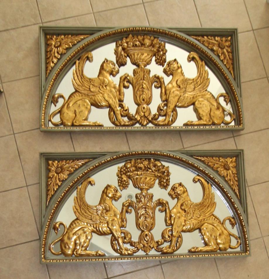 Spectacular pair of Griffin (lion) motif French architectural 23k giltwood Boiserie relief mirrored panels. Each panel is expertly detailed with carved griffins flanking a floral urn with mirror backing and green painted outer frame. The 19th