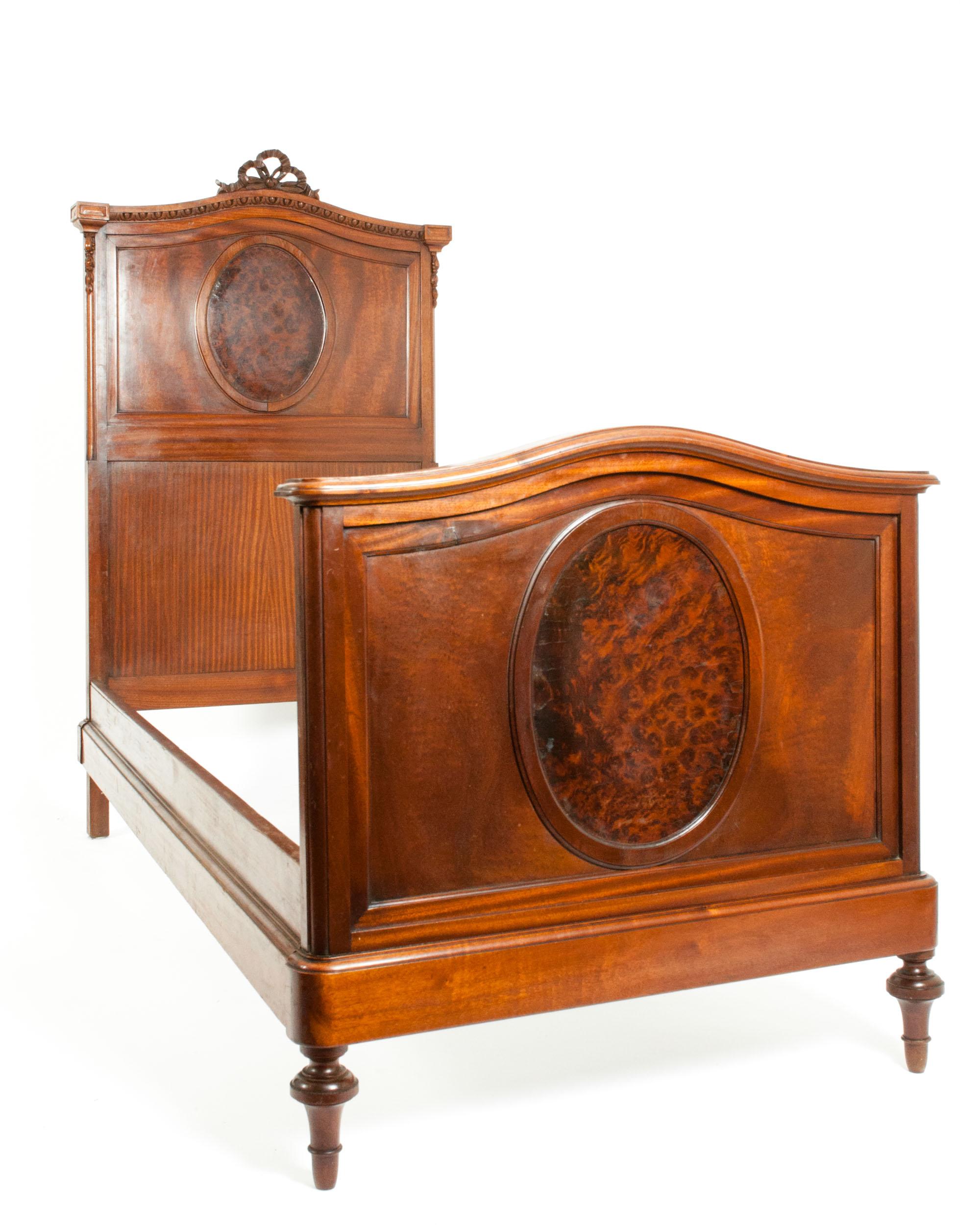Pair of French hand carved walnut and burl walnut with design detail single bed . Each bed is in good antique condition with appropriate wear consistent with age / use . The  footboard of one bed has been professionally repaired . Each one measure