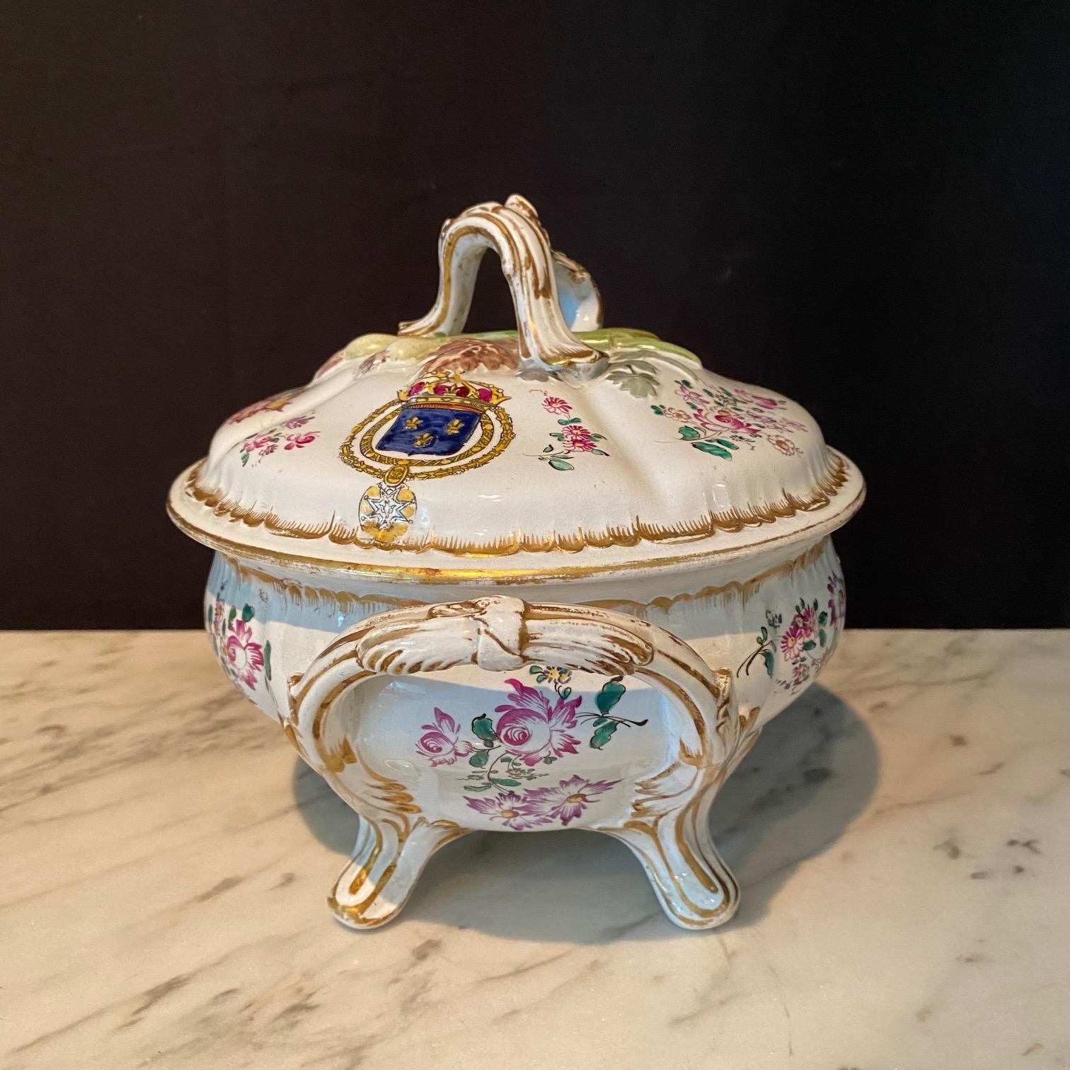 A lovely, highly-detailed pair of French faience soup tureens, with handles, feet and nicely-sculpted vegetable decorated cover (18th century). The top cover has leeks, flowers and herbs, and the painted decoration on the sides includes shields with