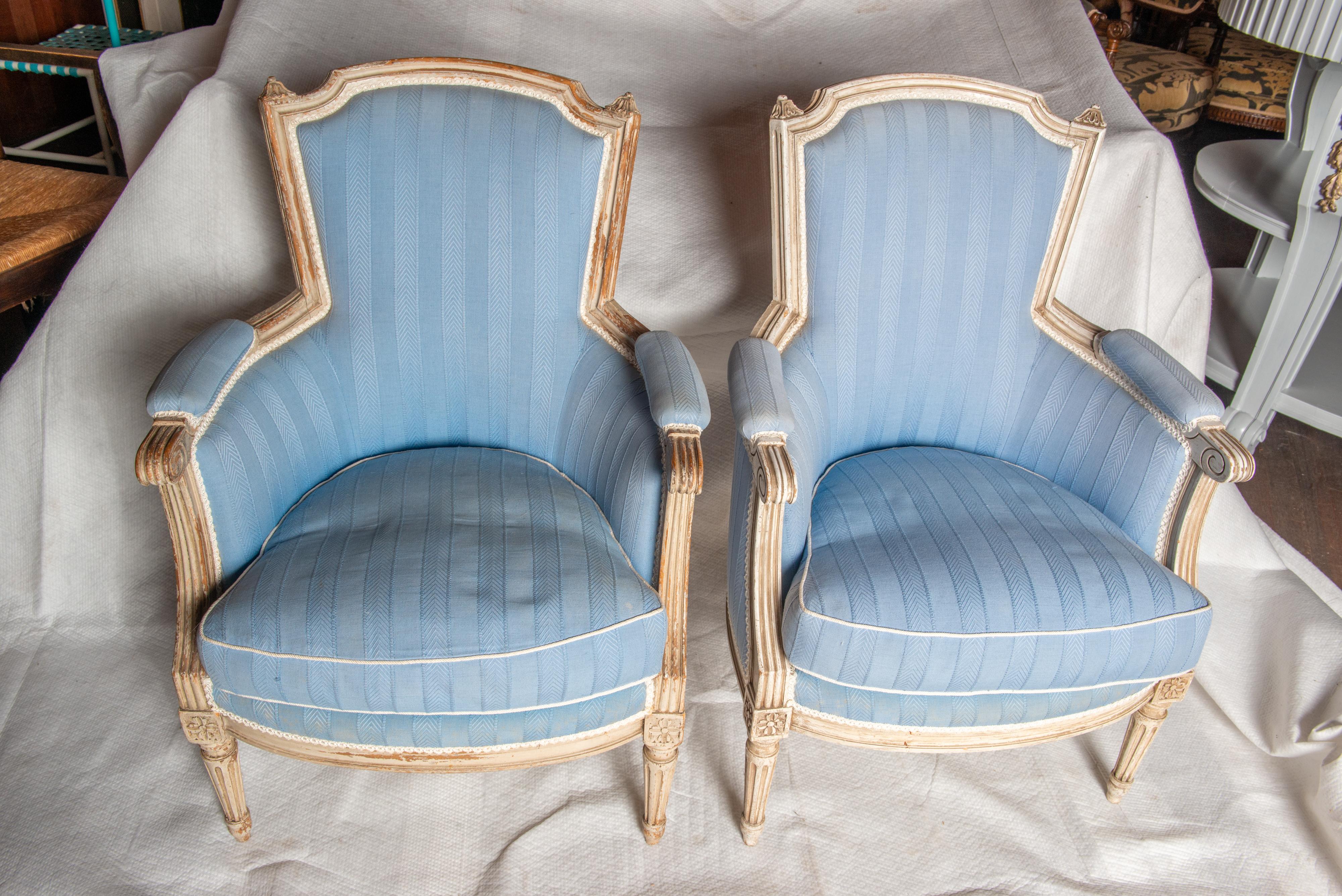An exquisite pair of cerused Louis XVI bergeres attributed to Maison Jansen 
in pristine blue upholstery. Classic beauties.
