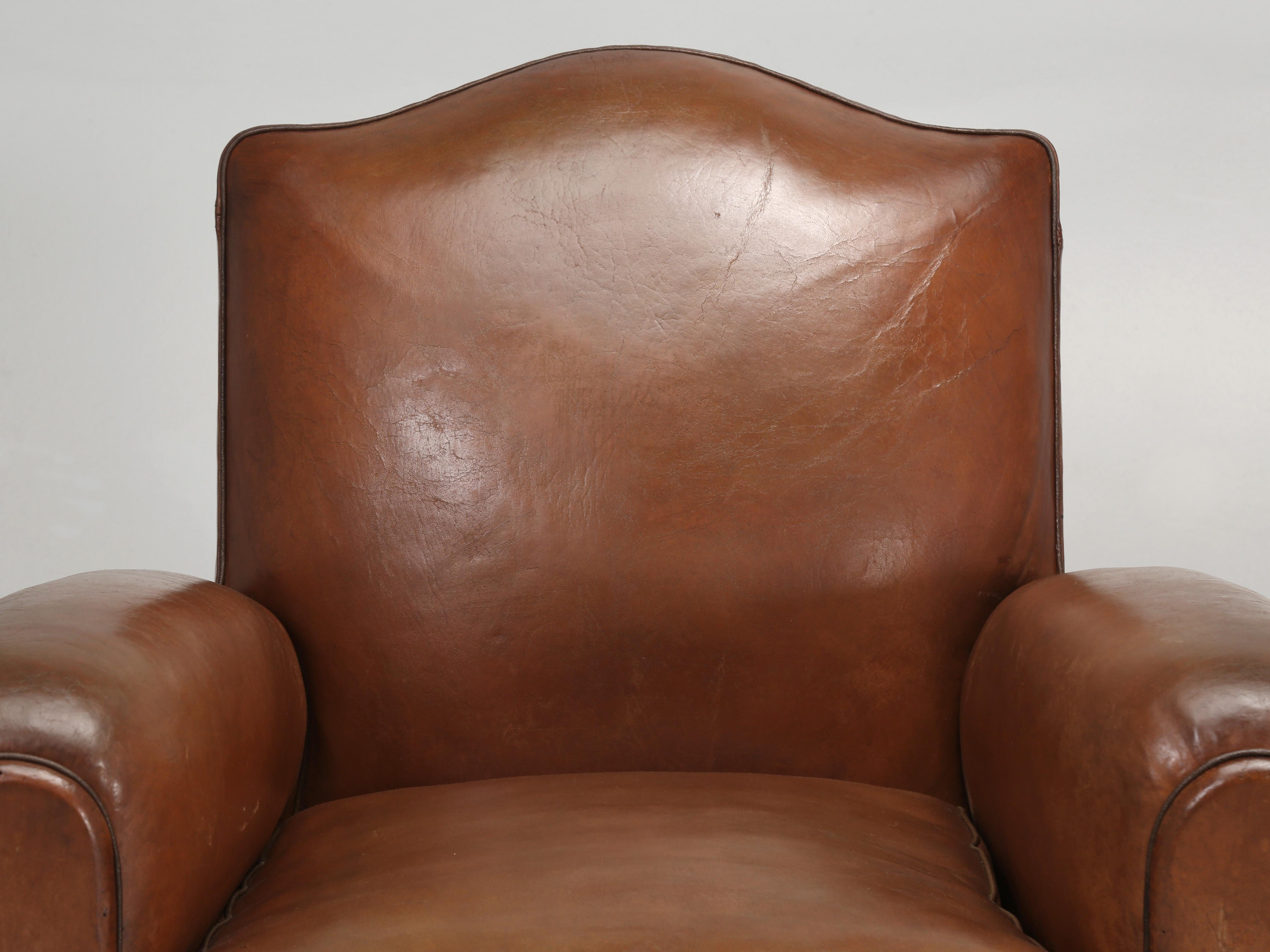 French leather pair of club chairs that are still in their original leather, although each leather club chair was rebuilt from the inside out, while not disturbing the original leather covering. Our inhouse Old Plank upholstery department rebuilt