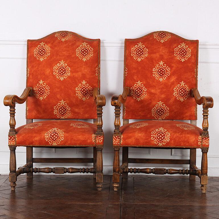 An early-20th century pair of French Louis XIII style open armchairs with turned legs and stretcher-base, and scrolled arms.

 