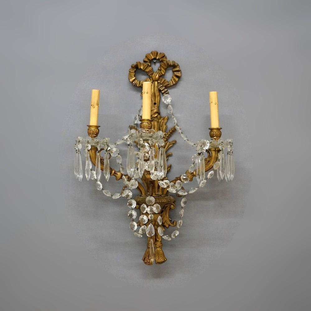 Antique pair of French Louis XIV wall sconces offers gilt bronzed metal construction in scroll and foliate form with three lights, c1920. 

Measures - 23