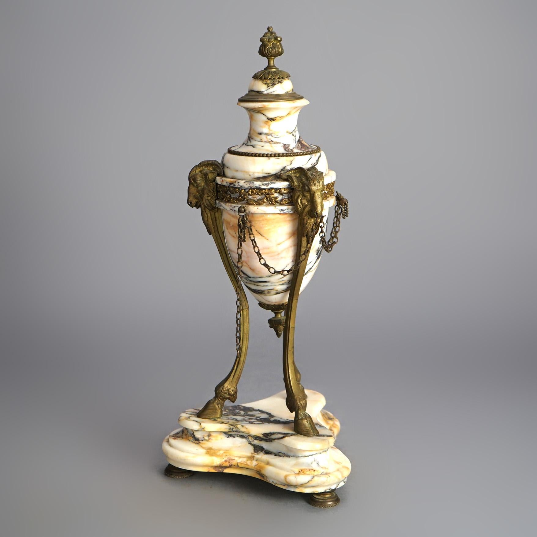 A pair of antique French Louis XV figural mantel urns offers deeply striated marble construction with cast ormolu mounts including ram heads, draped chain, foliate and floral elements and raised on hoof feet, 19th century

Measures- 17.5''H x 7.5''W