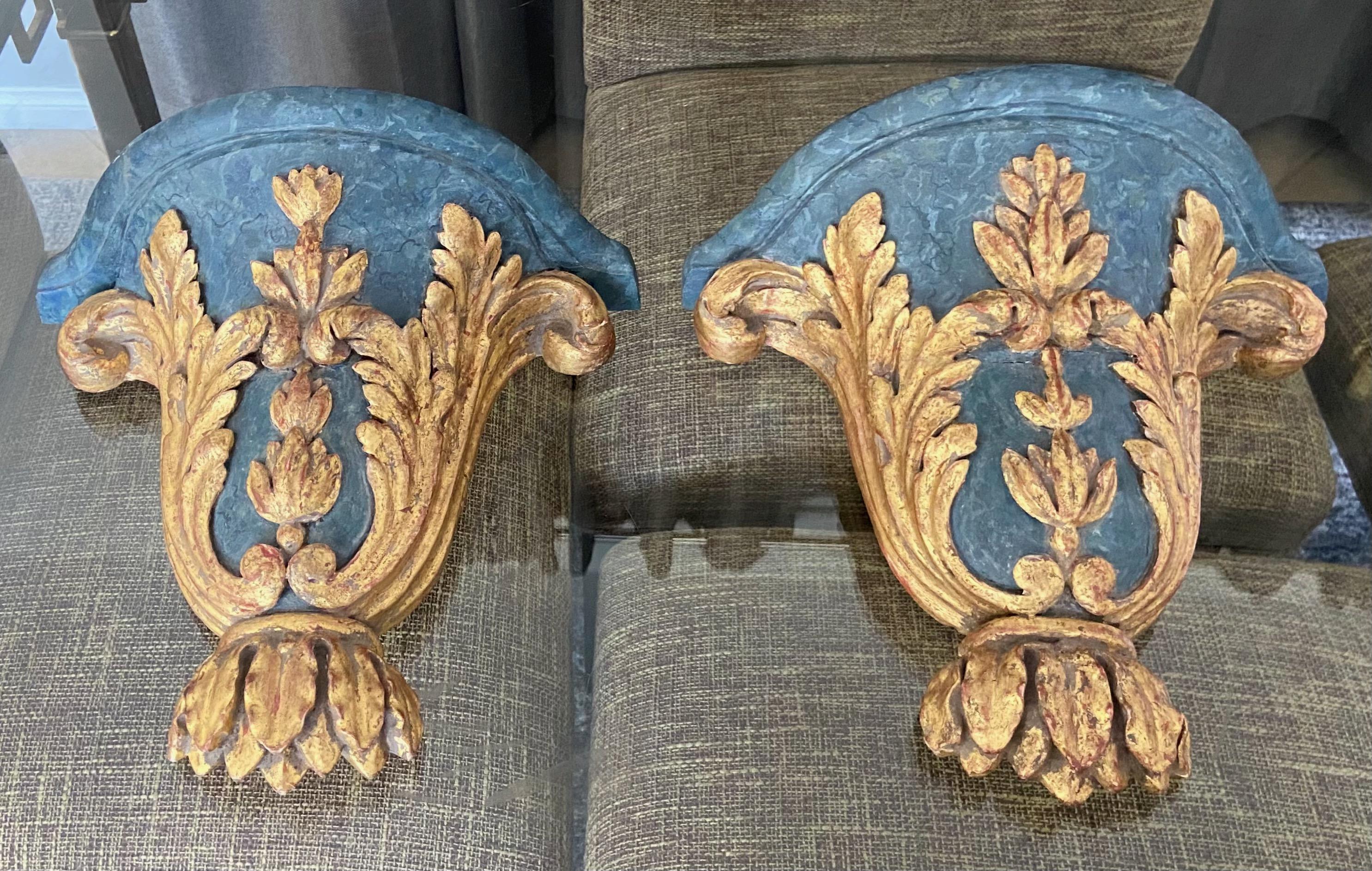 Pair of French Louis XV giltwood carved wall bracket shelves with partial blue faux marble painted finish. The brackets are expertly crafted highlighting an acanthus leaf motif.