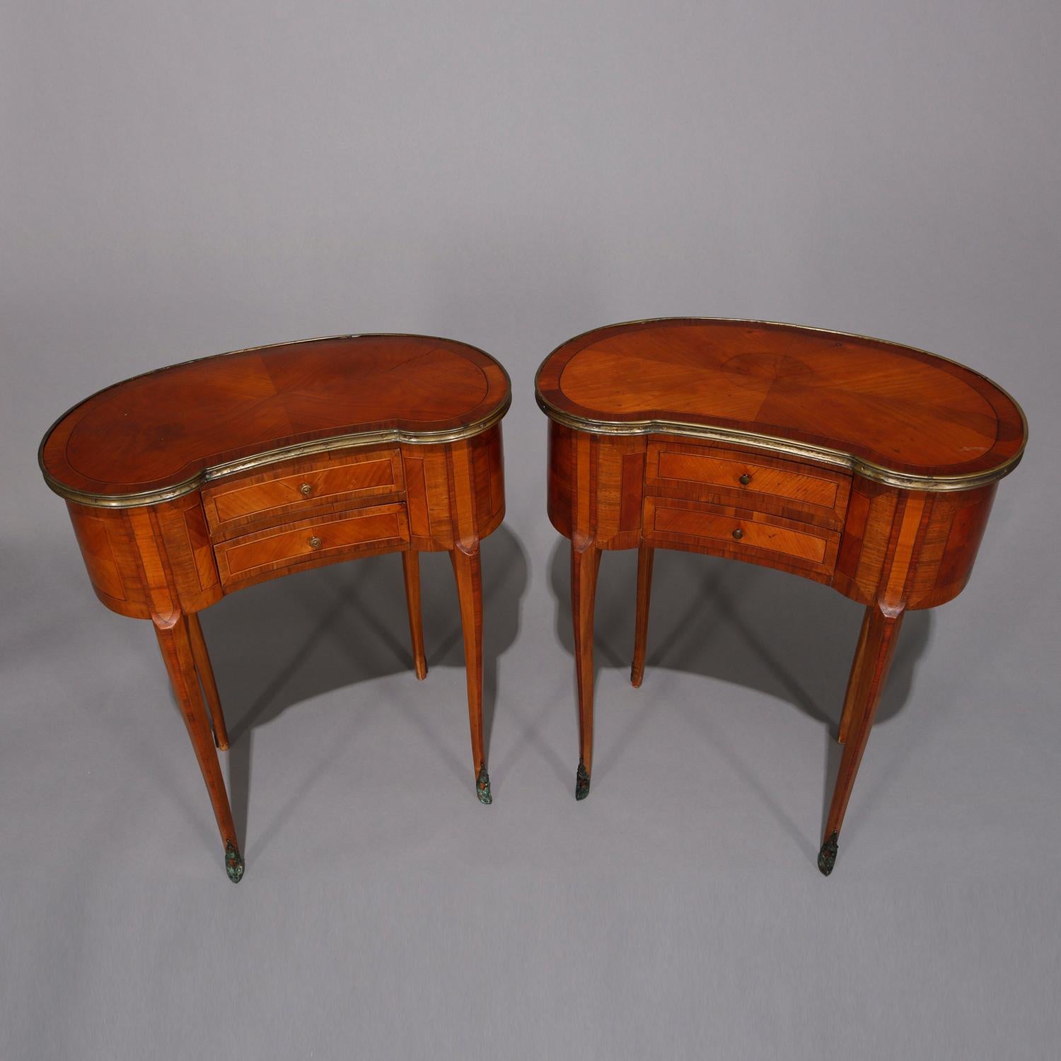 An antique pair of French Louis XV kingwood side stands offer kidney form with bookmatched tops having gilt banding, case with two drawers having satinwood banding, raised on cabriole legs terminating in feet with foliate form ormolu, circa 1920