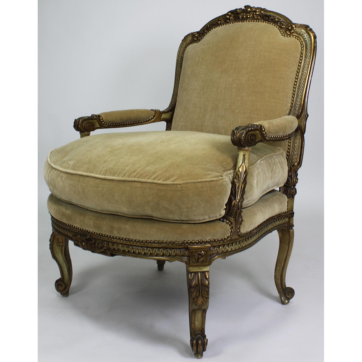Raffinata coppia di poltrone Fauteuils intagliate in stile Luigi XV, dorate e dipinte di verde-crema, attribuite alla Maison Jansen. La struttura dello schienale ad arco è coronata da intagli di fiori con braccioli aperti e sollevata su gambe