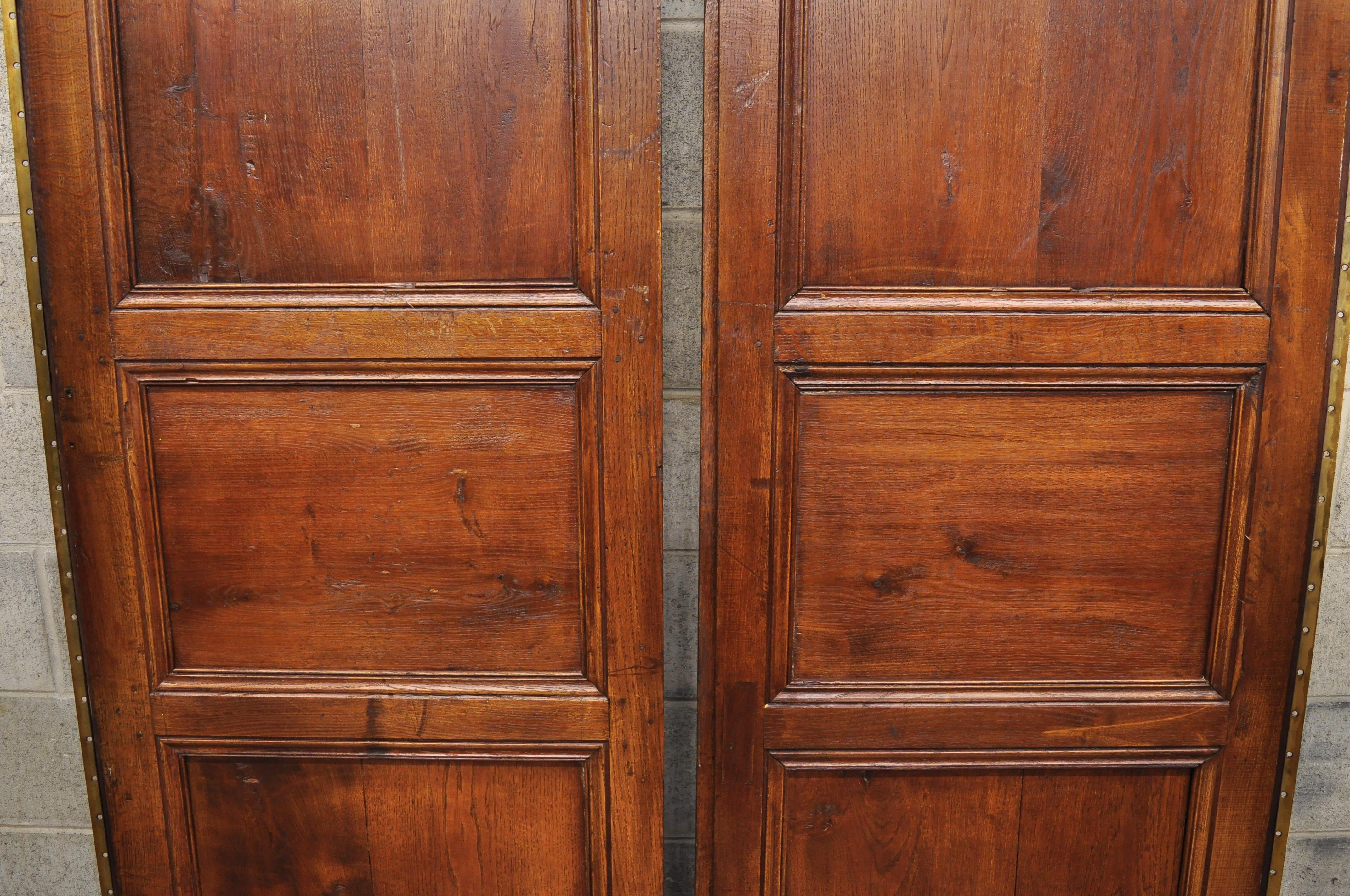Pair of antique French Louis XVI style carved oak interior double doors with bronze rococo door knobs (B) circa 19th century. Measurements: (Each door) 91
