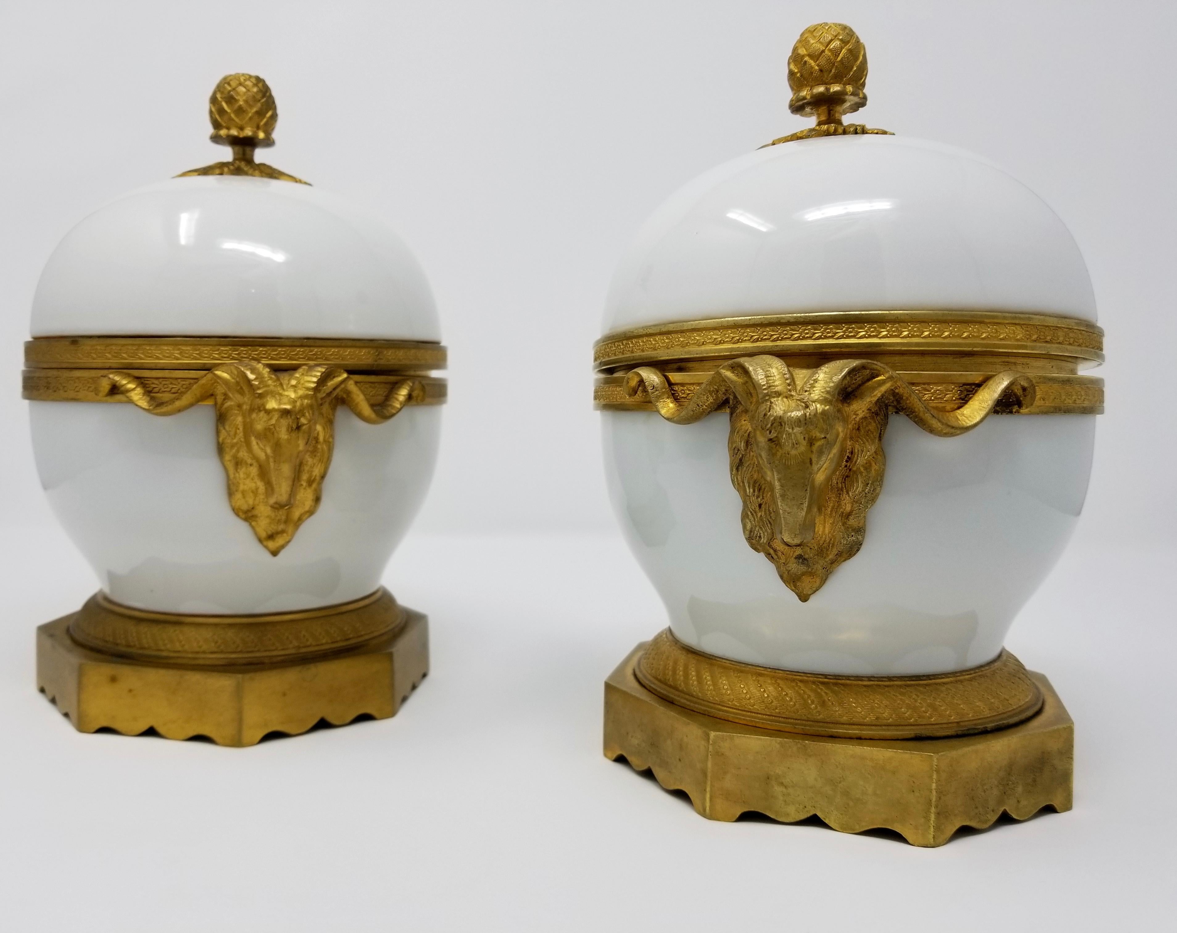 A beautiful pair of 19th century Louis XVI style French ormolu-mounted white porcelain and doré bronze ram's head handle covered bowls. Each bowl is of the finest French opaque white porcelain, with gorgeous hand chased doré bronze mounts, rams