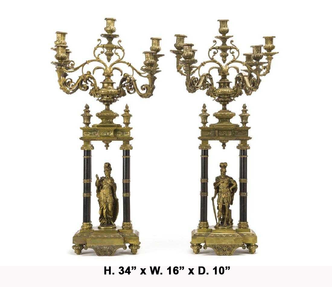 Massive pair of French Louis XVI style bronze figural candelabras of male and female Roman Centurion.
Surmounted by seven scrolling arms terminating in intricate foliate-cast bronze candleholders, above an ormolu frieze mounted with four fluted