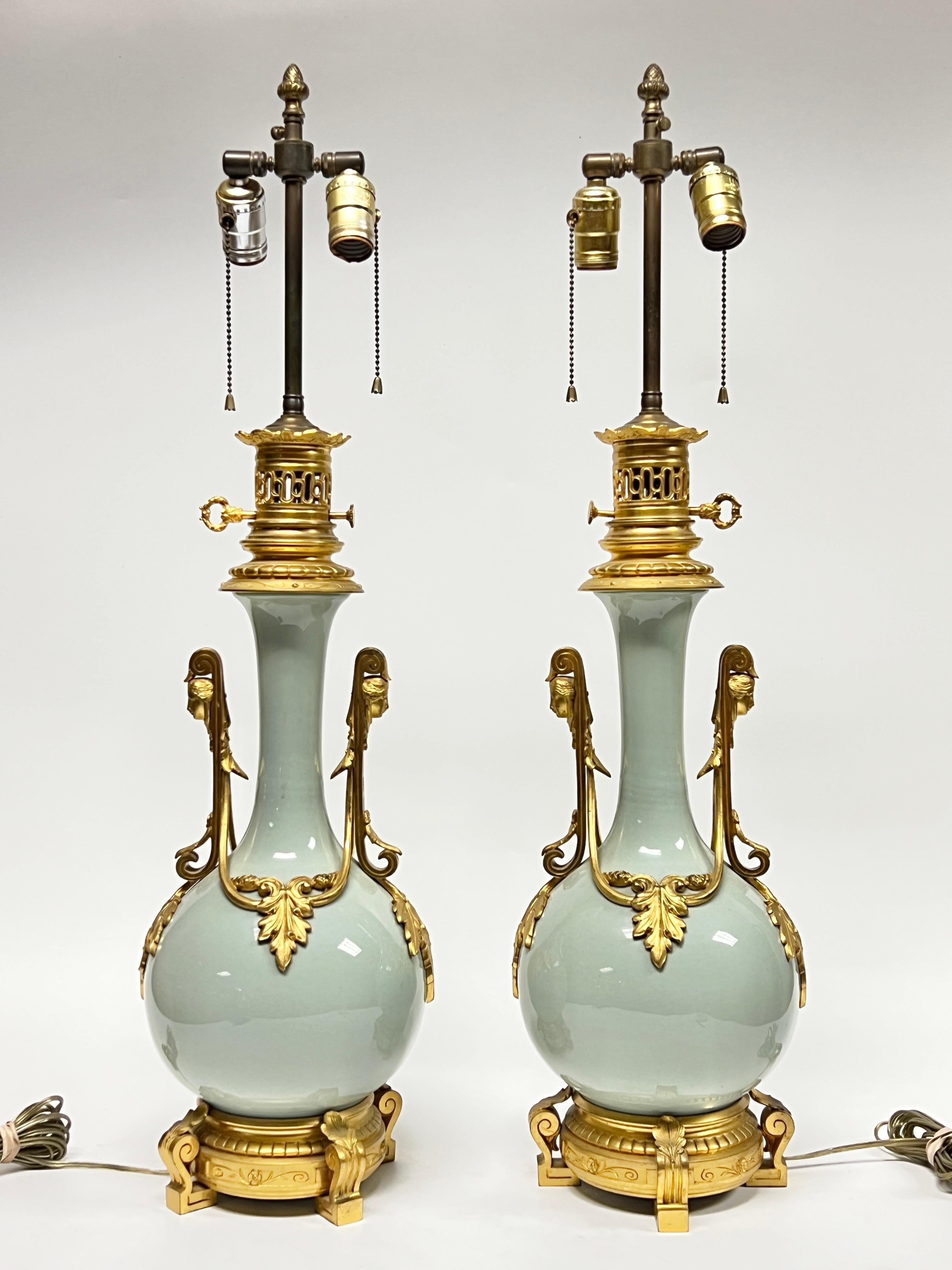 Paire de vases anciens en porcelaine émaillée céladon avec montures en bronze doré, de style néoclassique Louis XVI, conçus à l'origine comme des lampes à huile auxquelles ont été ajoutés plus tard des douilles et des câbles.  Ils se distinguent par
