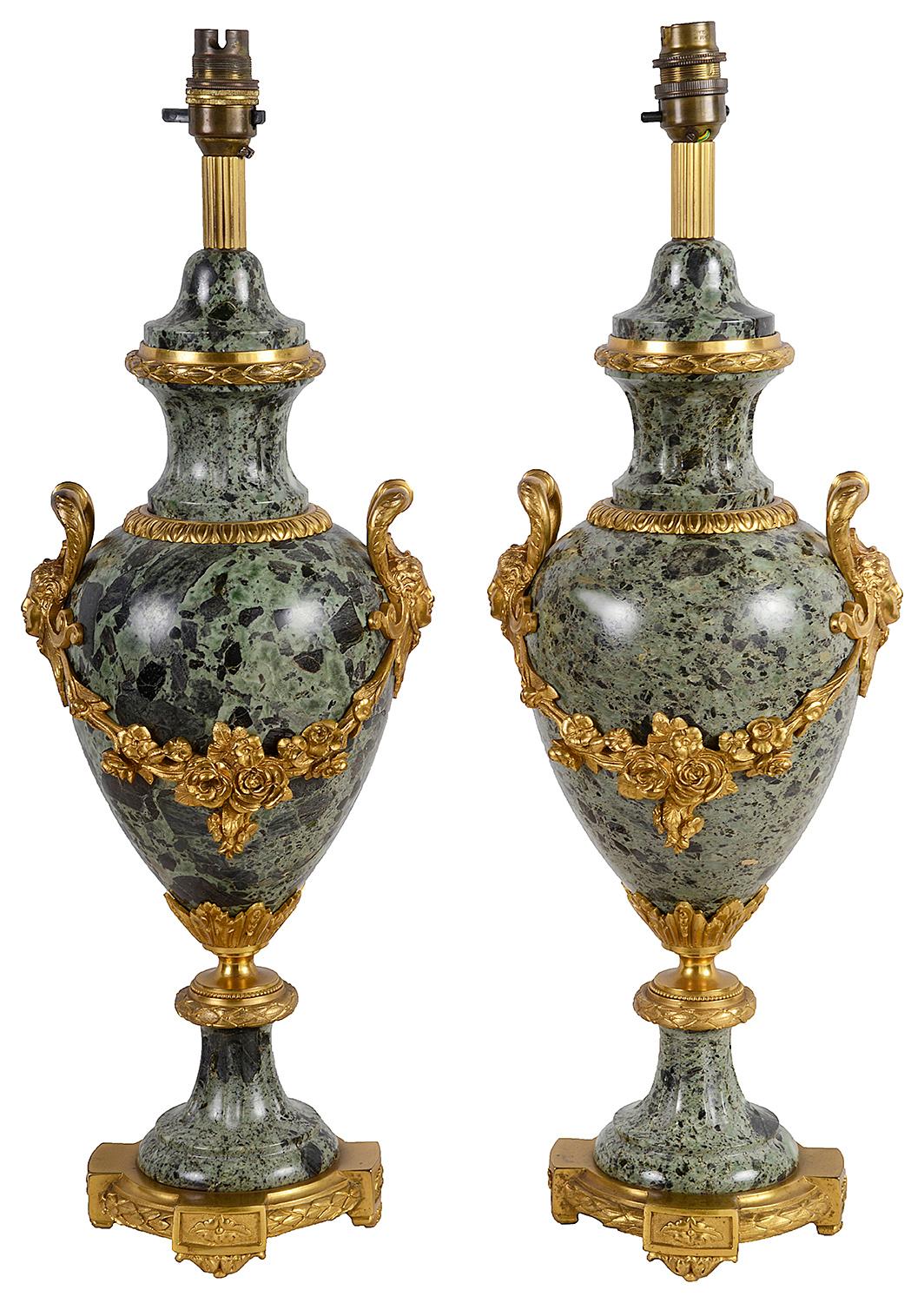 A good quality pair of late 19th century French green marble and gilded Ormolu vases / lamps. Each with classical mask mounts below the handles, garlands of flowers and raised on pedestal bases, terminating on Ormolu plinths. Measures: 46cm (18