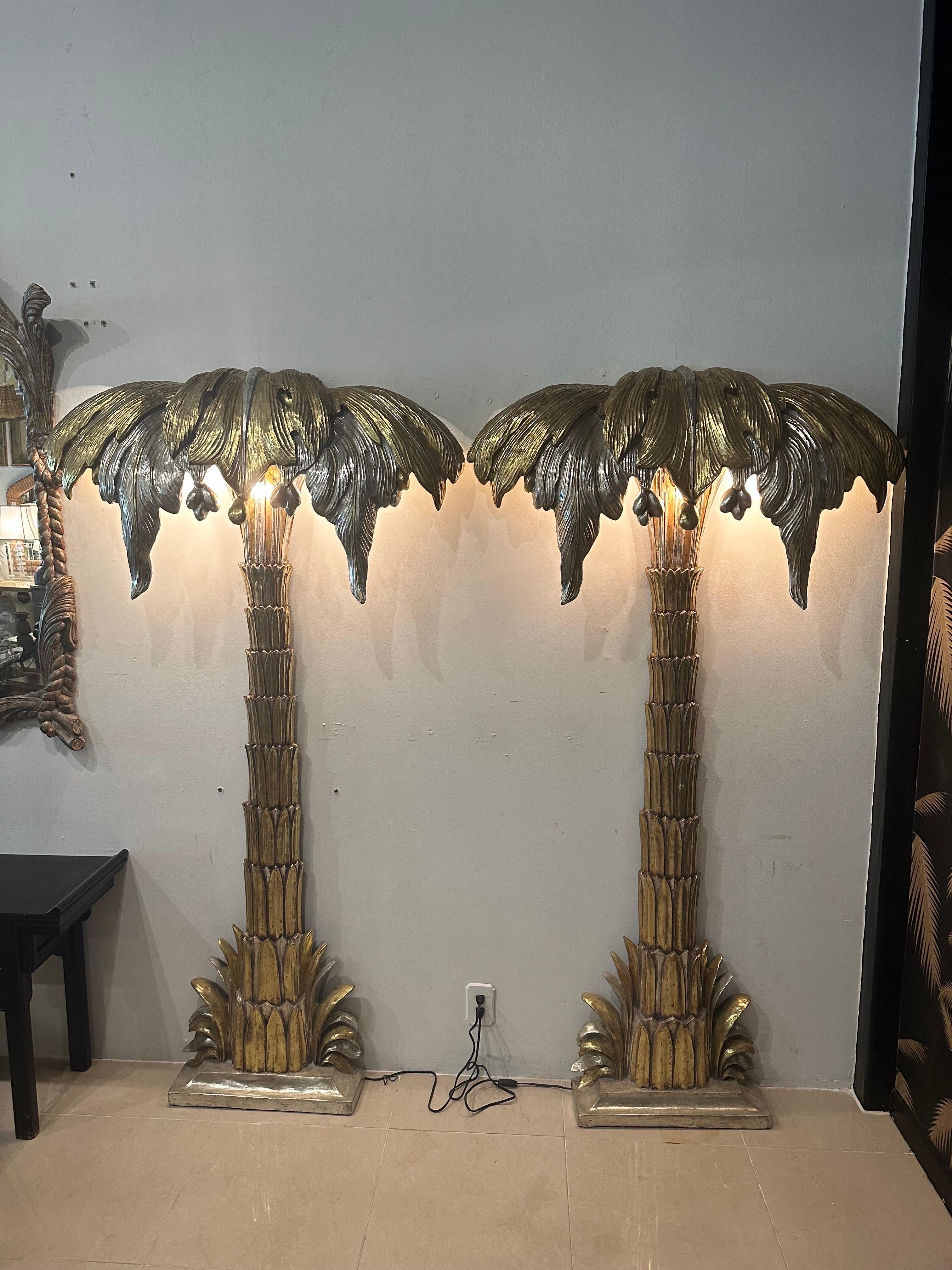 Amazing pair of monumental size palm tree wall floor lamps by Maison Jansen. Silver and gold gilt. Original finish. No chips or breaks. These each have 3 lightbulbs underneath the palm leaves. These have EU converter parts that screw into the light