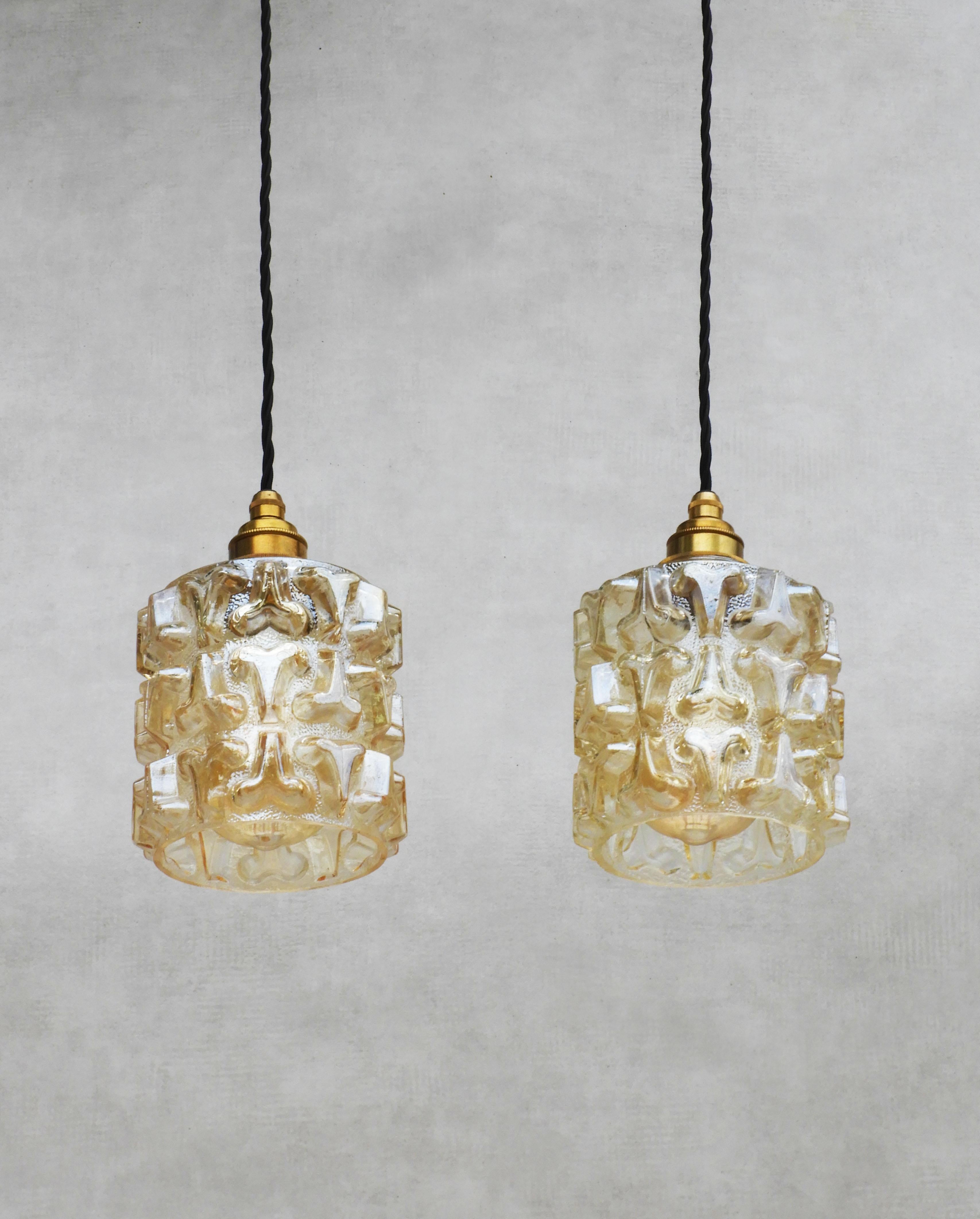 Un par de inusuales lámparas colgantes de cristal de la Francia de mediados de siglo C1970.
Dos pantallas de cristal facetado texturizado en sutil ámbar dorado perlado. Elegantes y versátiles, estas lámparas colgantes pueden colgarse agrupadas o