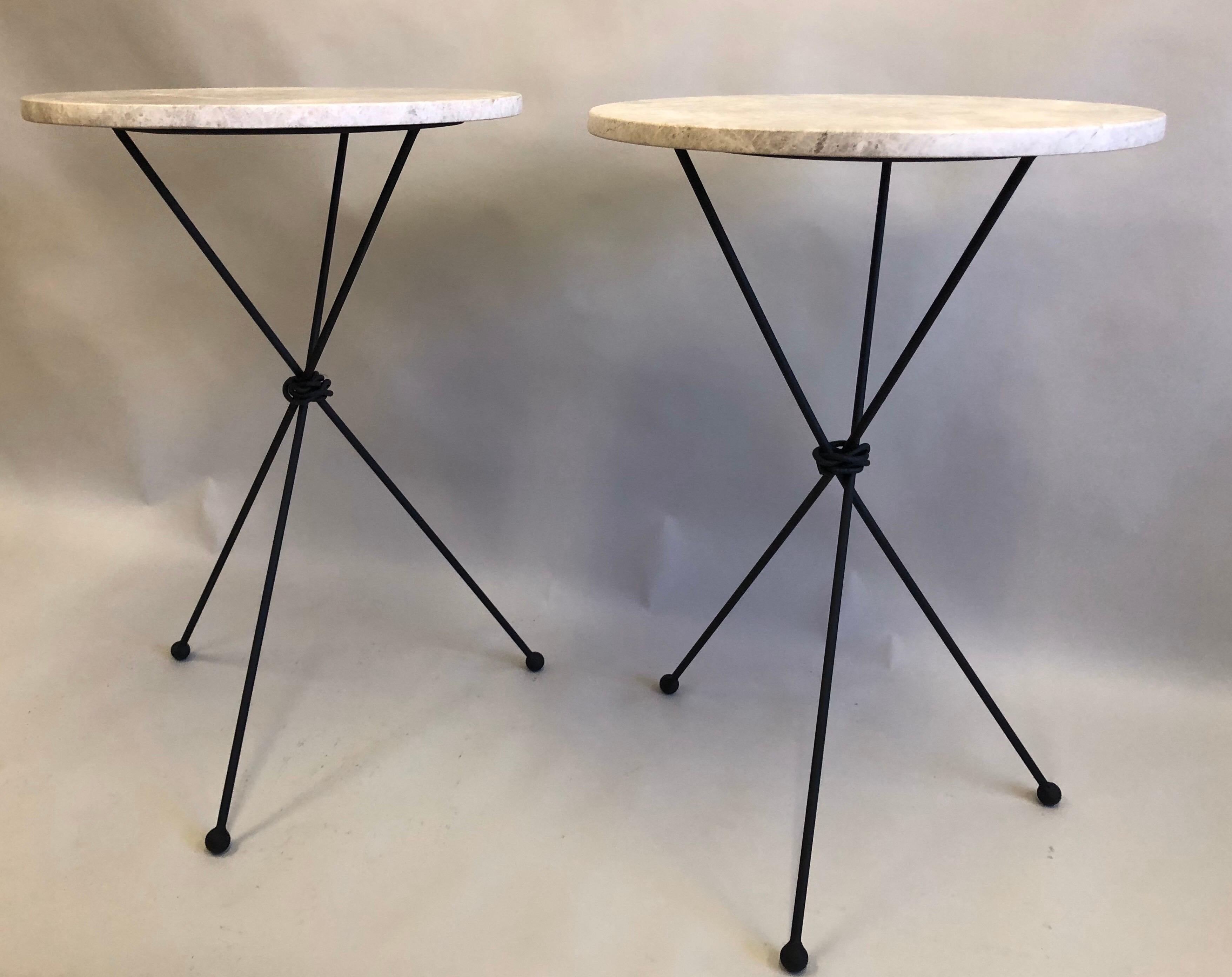 Elegant Pair of French Mid-Century Modern Style Wrought Iron and Limestone Side or End Tables in Style of Alberto and Diego Giacometti for Jean Michel Frank.

Each table sits on a hand-hammered wrought iron tripod base with ball feet and the legs.