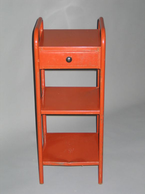 Iconic pair of French Mid-Century Modern end / side tables or nightstands in dark red laminated steel in the manner of Jean Prouve. 

Project for the Sanitorium in Savoy. Each contains 3 shelves and 1 drawer.