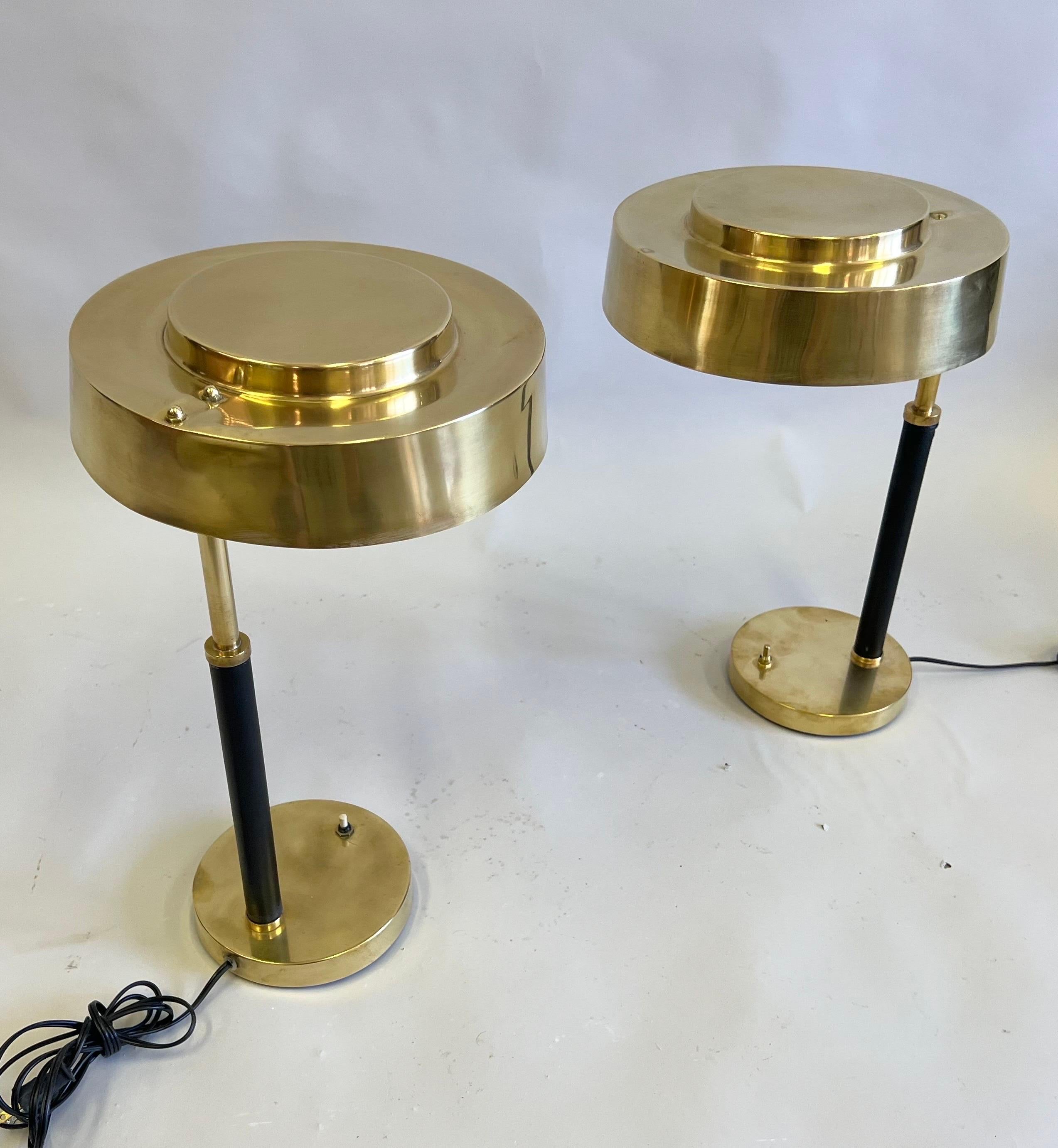 An Elegant and Timeless Pair of French Mid-Century Modern late / Art Deco table or desk lamps in solid brass with the stems delicately wrapped in black leather. The lamps are attributed to Jacques Adnet circa 1930 -1935 and are emblematic of the