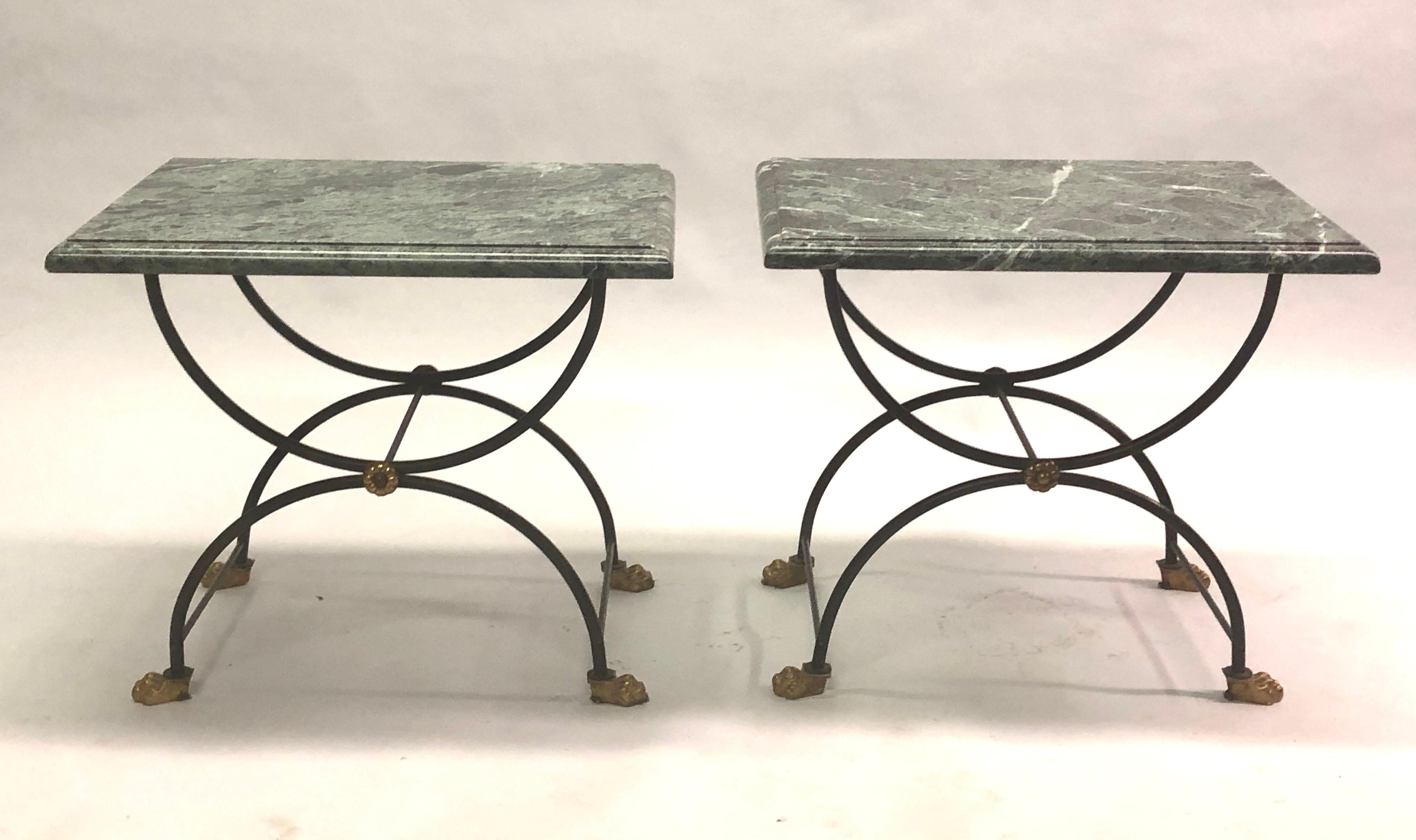 Pair of French Mid-Century Modern neoclassical end or side tables attributed to Jean-Charles Moreux for Maison Jansen. 

The tables feature wrought iron bases in a classic X frame Curile form, beveled thick marble tops and are finished with gilt