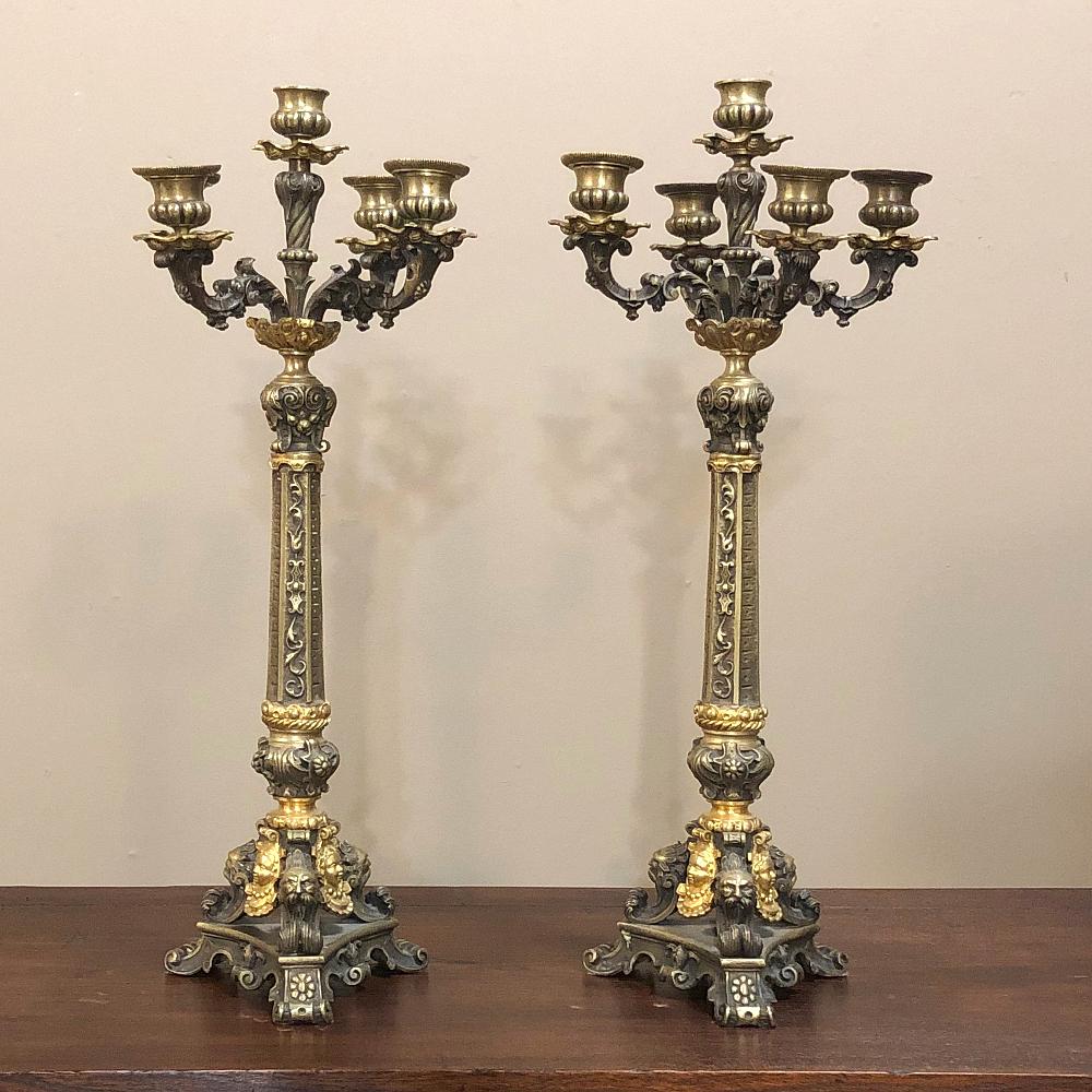 Pair French Napoleon III Period bronze candelabra are a true feast for the eyes! Hand-cast and chased from polished bronze and patinaed bronze for a two-toned effect, each has been elaborately designed with a Renaissance Revival flair in the style