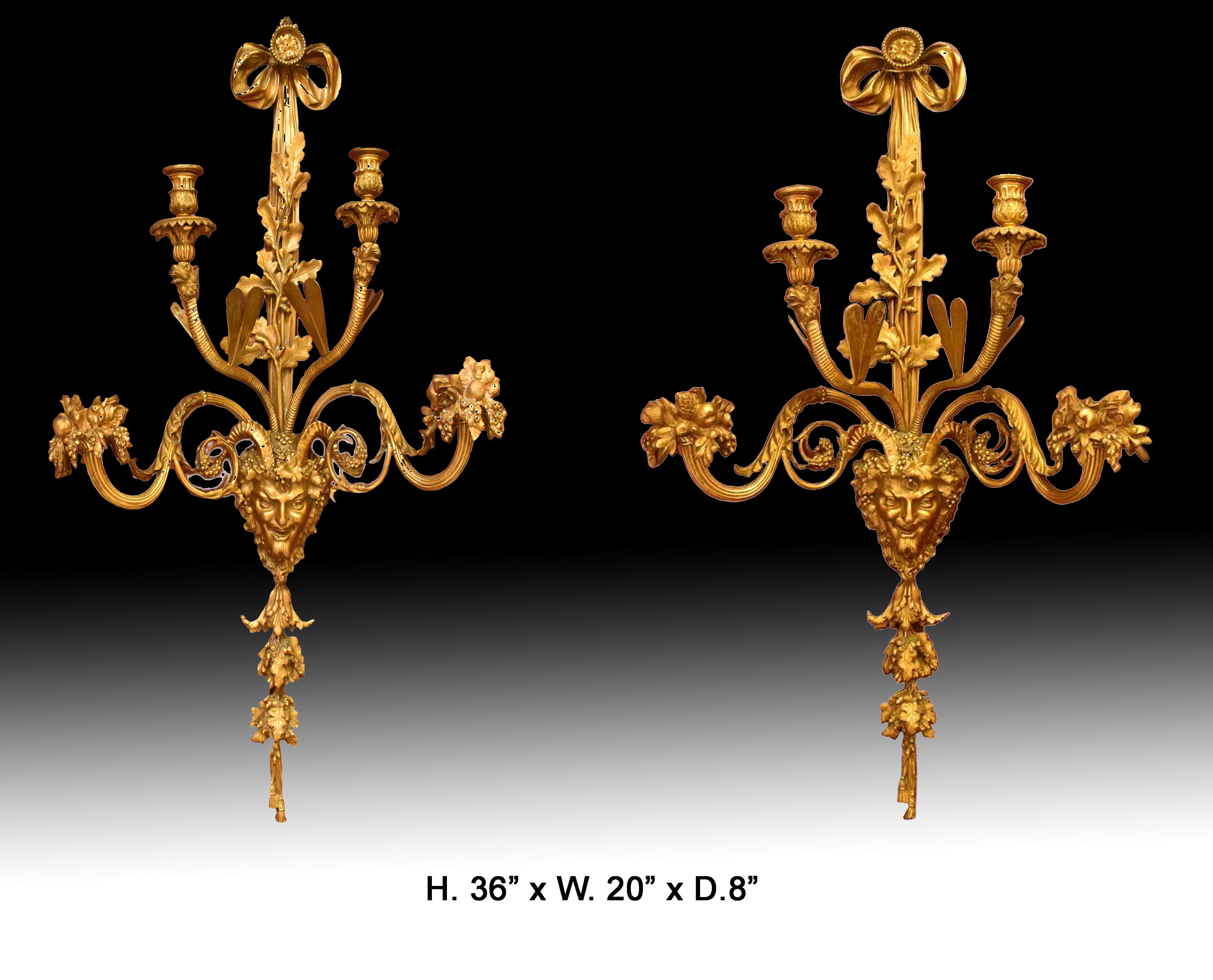 Exquise paire d'appliques à 4 lumières de style Louis XV du 19ème siècle.
Chacune d'elles est surmontée d'un ruban, au-dessus d'un feuillage complexe en bronze doré et d'un masque mythique, et de deux bras de candélabre anglés avec des ailes de