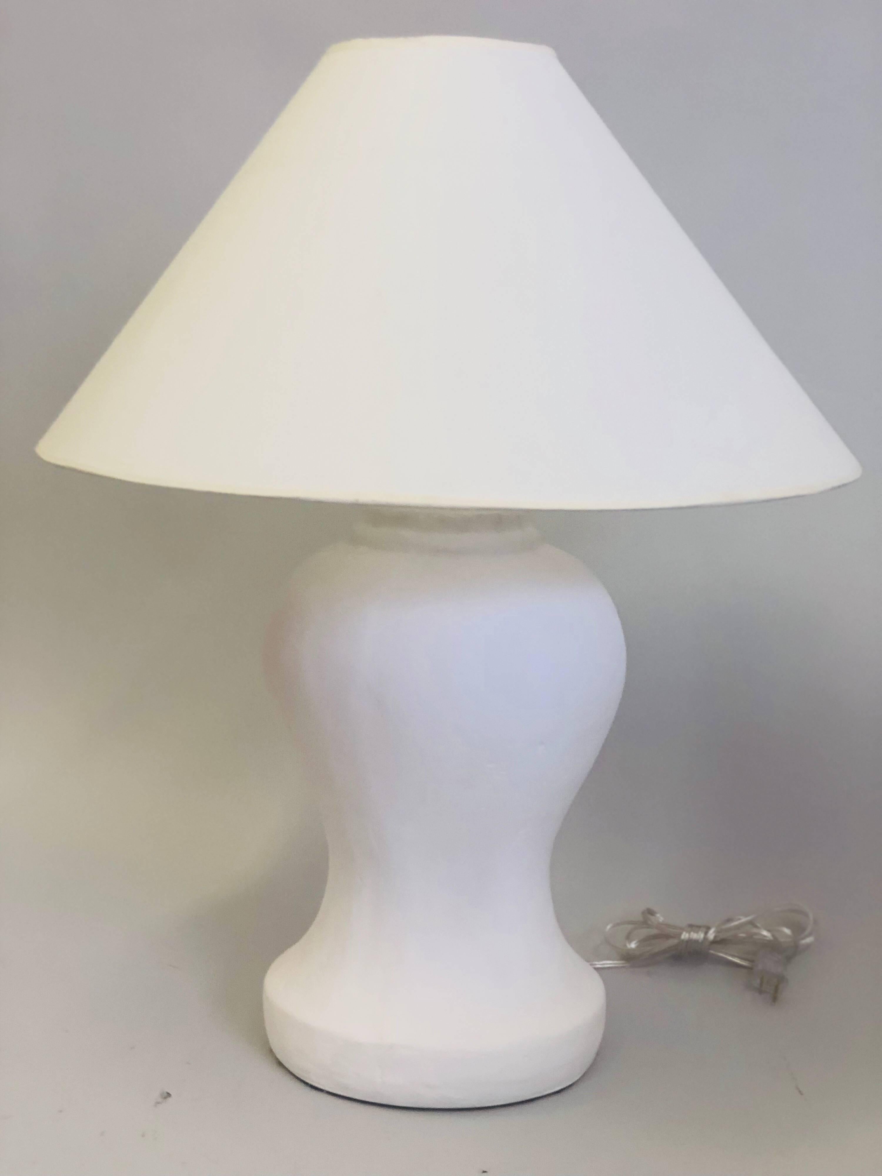 Pair of French Mid-Century Modern style white plaster table lamps from a model by Alberto Giacometti & Jean-Michel Frank. These lamps are based on a 1935 model by Alberto Giacometti for the Marianne table lamp. A variation of that lamp was later