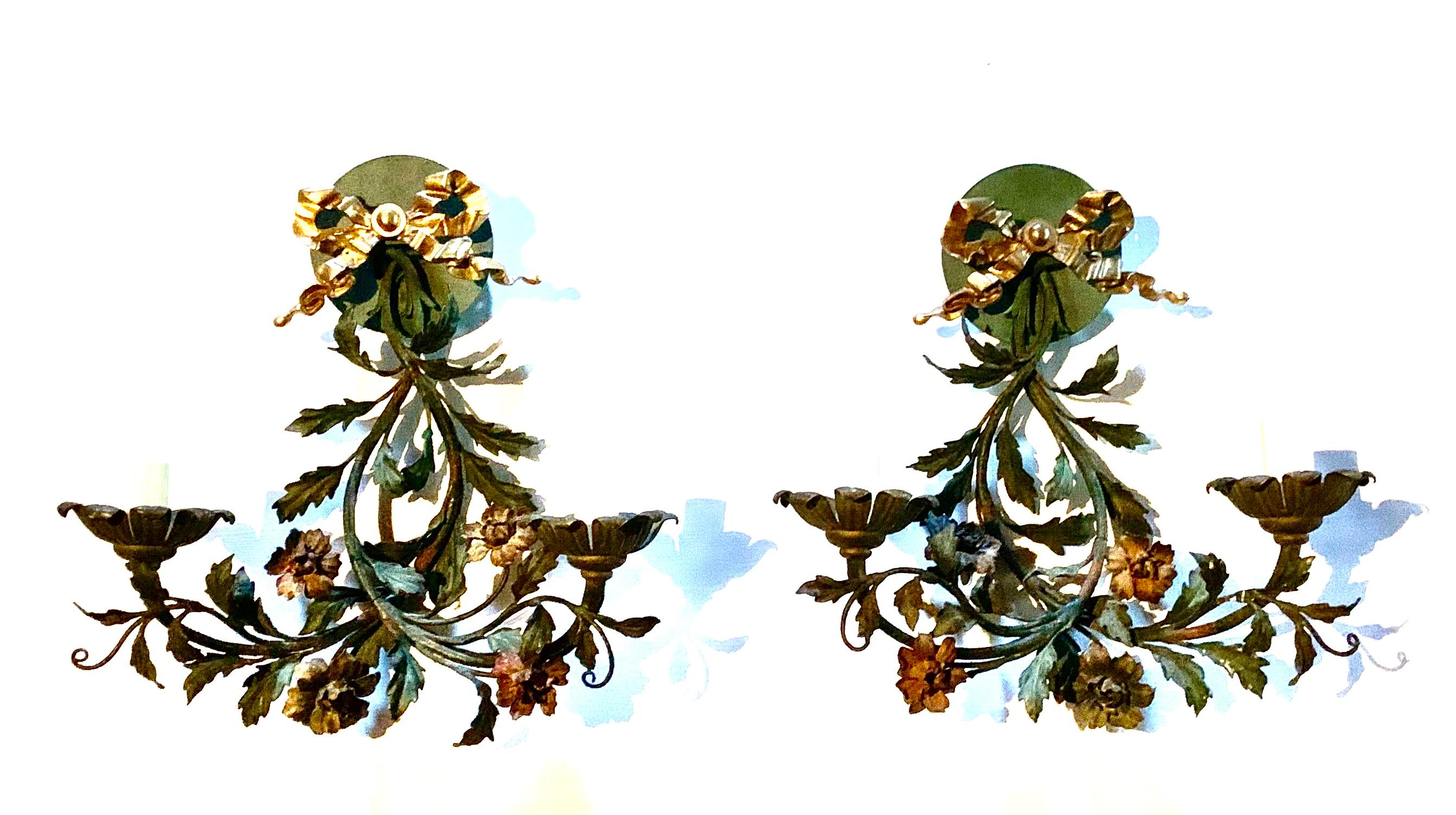 Fine quality, charming pair of 19th century French Provincial Tole and Bronze floral motif two light wall sconces. Polychrome decorated tole in subtle, muted tones of forest green, ochre and rust with beautiful gilt bronze bows at the wall plates.