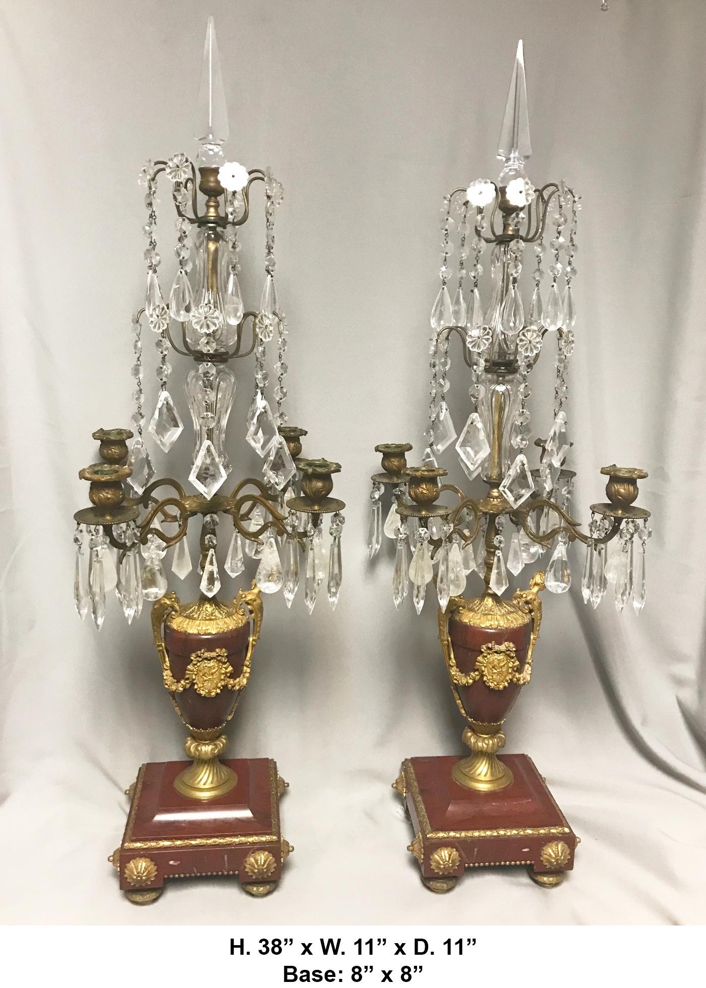 Extremely fine pair of 19th century French Louis XVI style ormolu mounted rouge marble four-light girandole lamps.

The beautiful girandoles are surmounted by a cut crystal spike, above two tiers of cut crystal prisms and adorned with Rock Crystal