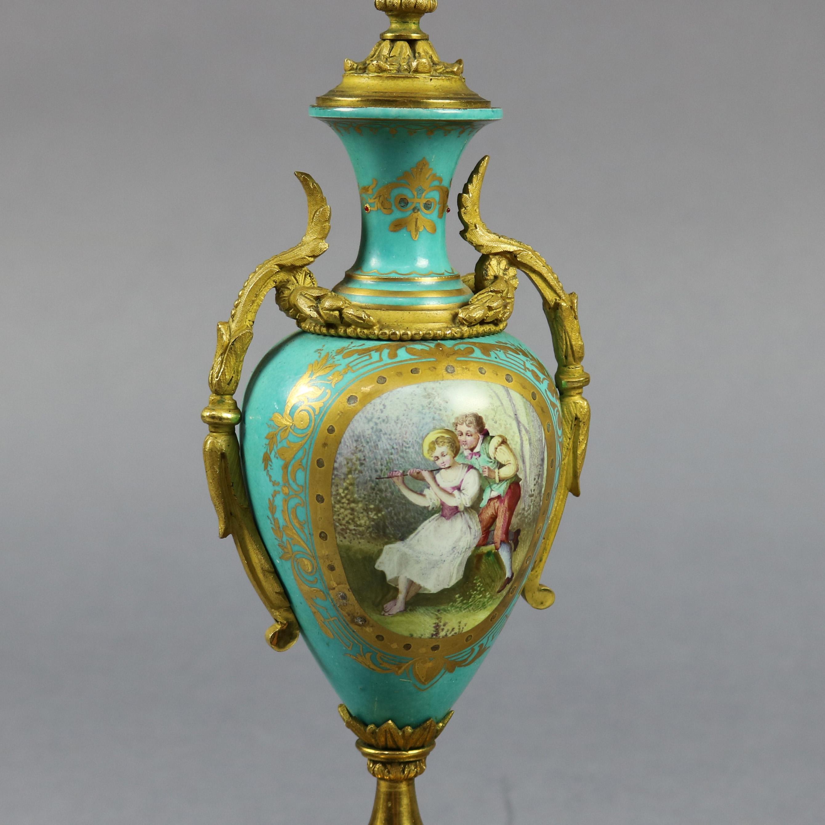 Pair of French Sevres School urns offer hand painted porcelain vessels having reserves with courting couples and landscape scenes, gilt foliate decoration and cast bronze handles, seated on shaped gilt and velvet plinths, circa 1880

Measures: