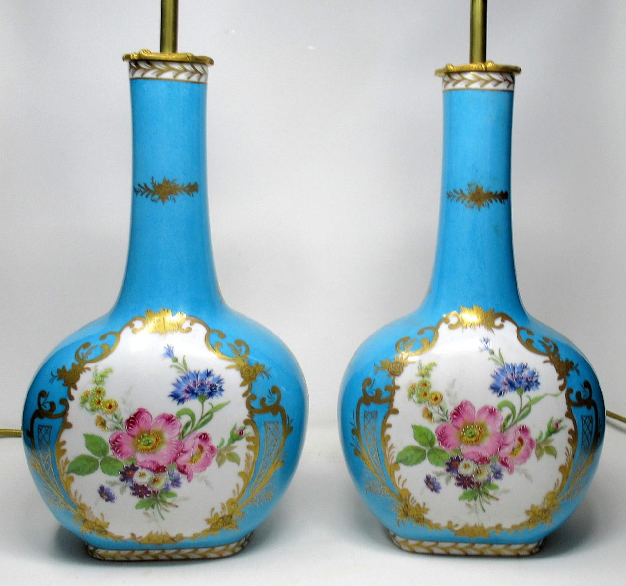 Stunning pair of French Sevres or Limoges style porcelain bottle vases now converted to electric table lamps of good size proportions.

First quarter of the 20th century.

The hand painted central reserves depicting summer flowers within ornate