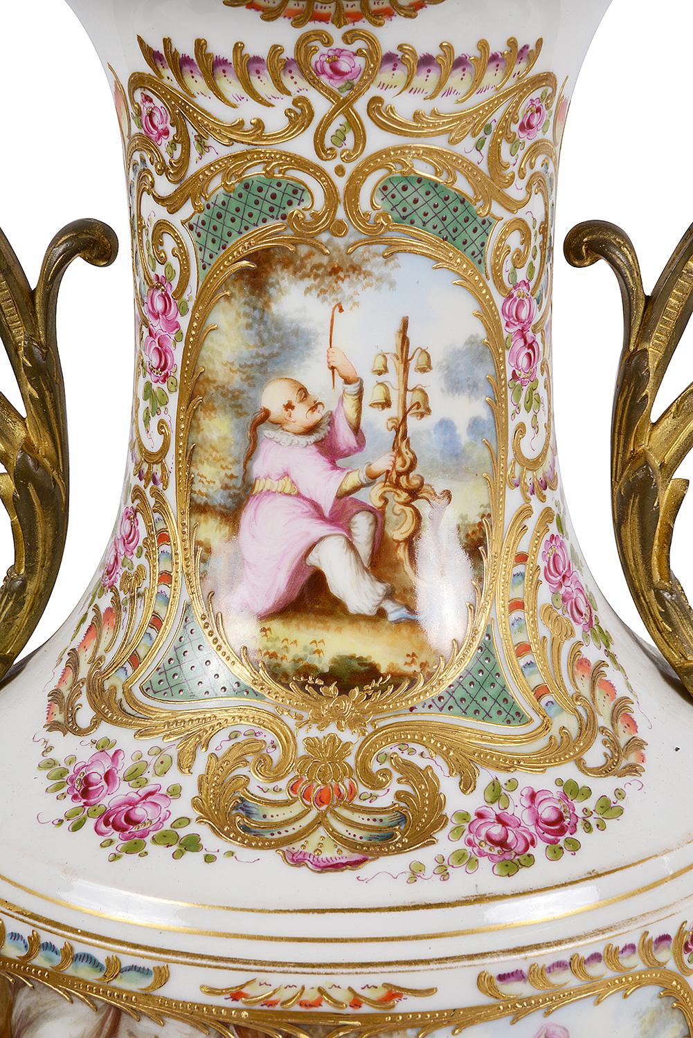 A very good quality pair of late 19th century French sevres porcelain lidded vases. Each with gilded ormolu handles either side and unusual inset hand painted romantic chinoiserie scenes with a white ground. Measures: 24.5