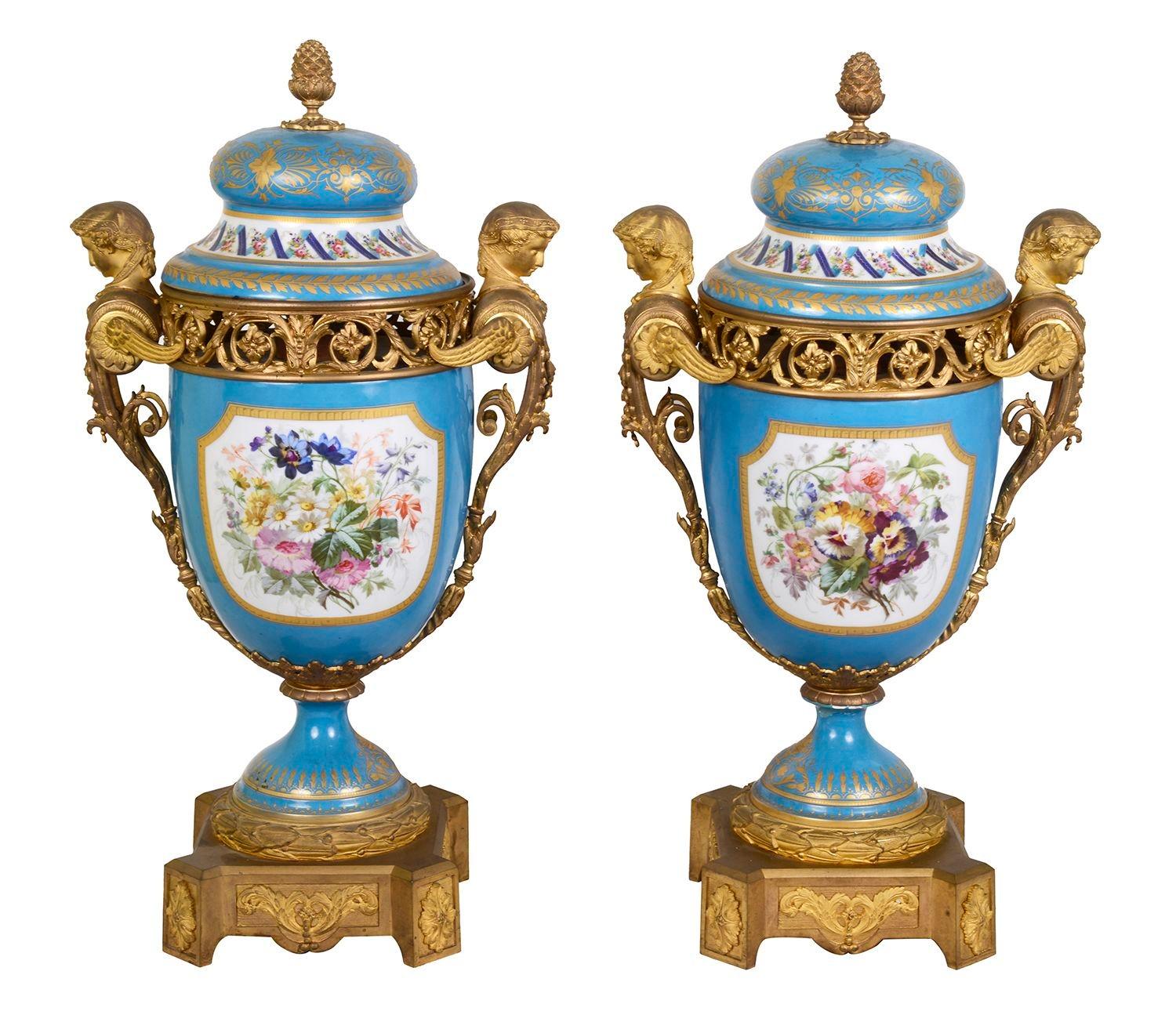 Un'impressionante coppia di vasi in porcellana di Sèvres della fine del XIX secolo, ciascuno con splendide montature in ormù dorato e maniglie monopodiali su entrambi i lati. Il fondo è turchese con riflessi dorati e inserti dipinti a mano che