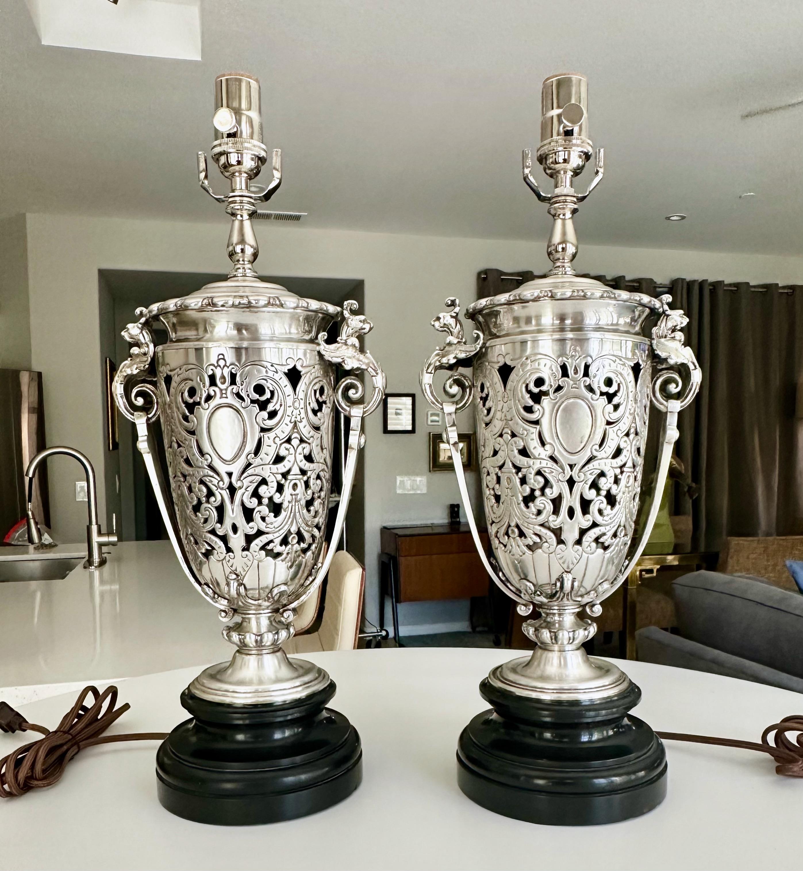 Pair of 1920's French Neo-classic style sterling silver plated table lamps. Expertly crafted with intricate pierced filagree, and Griffith lion head handles, resting on  and carved granite stone bases. The sterling silver plate is in excellent