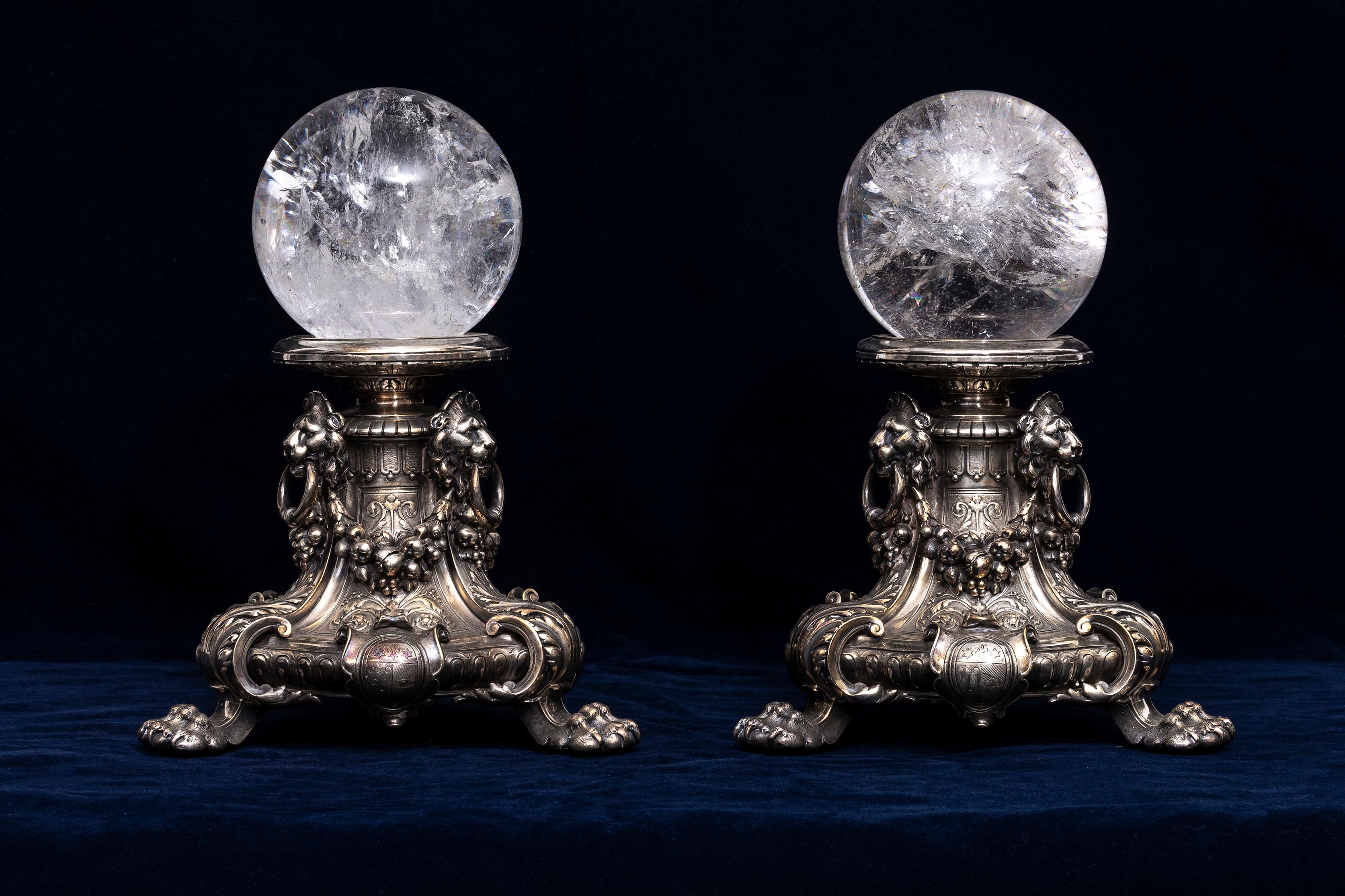 A Pair of Incredible French 19th Century Louis XVI Style Silvered Bronze Lions Mask Plinths with Hand-Carved and Hand-Polished Rock Crystal Orbs.  Boasting sumptuous French Regency design, this pair of orbs stand atop an intricate, high-relief