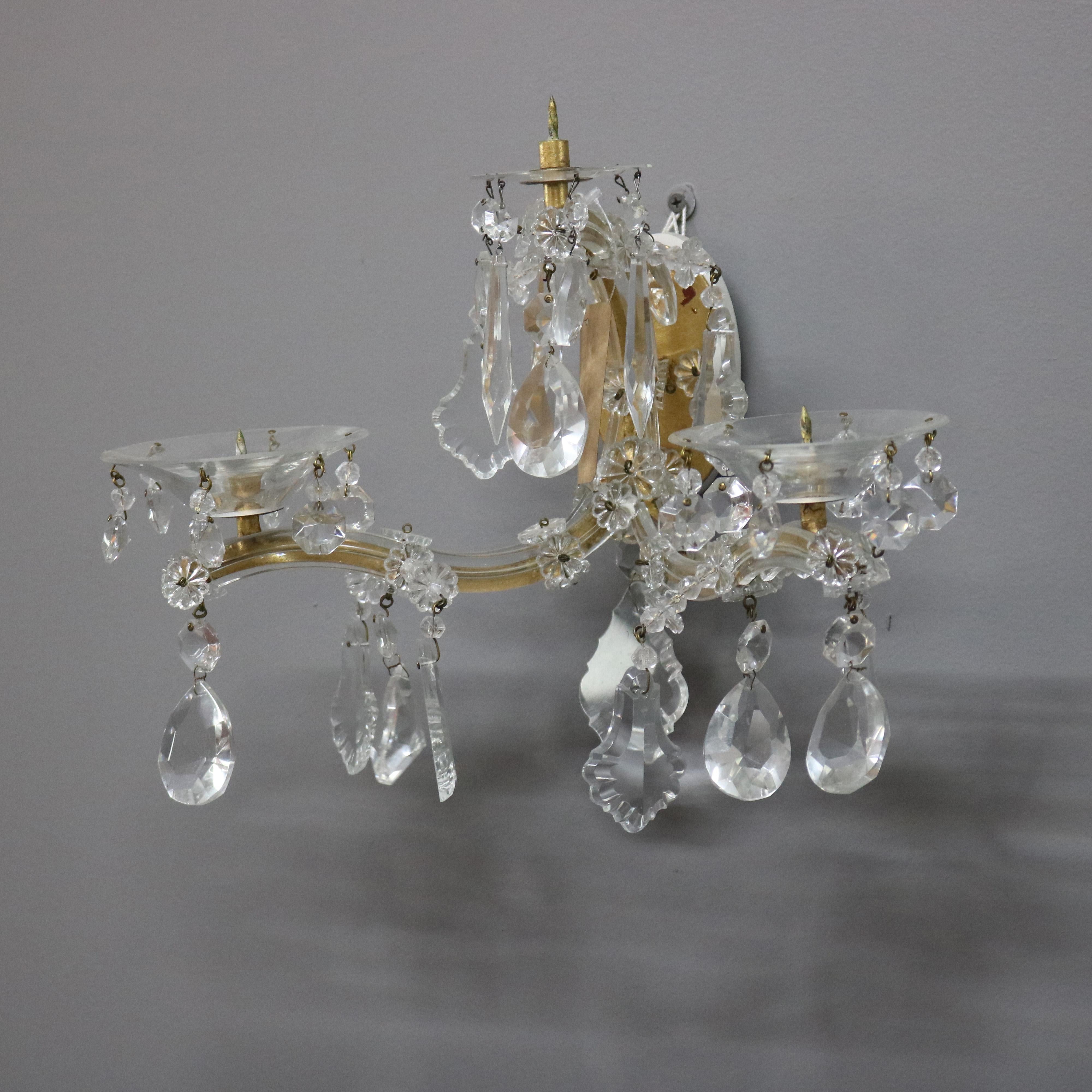 A vintage pair of French wall sconces offer brass frame with double c-scroll arms terminating in candle spires, cut crystal highlights throughout, circa 1930.

***DELIVERY NOTICE – Due to COVID-19 we are employing NO-CONTACT PRACTICES in the