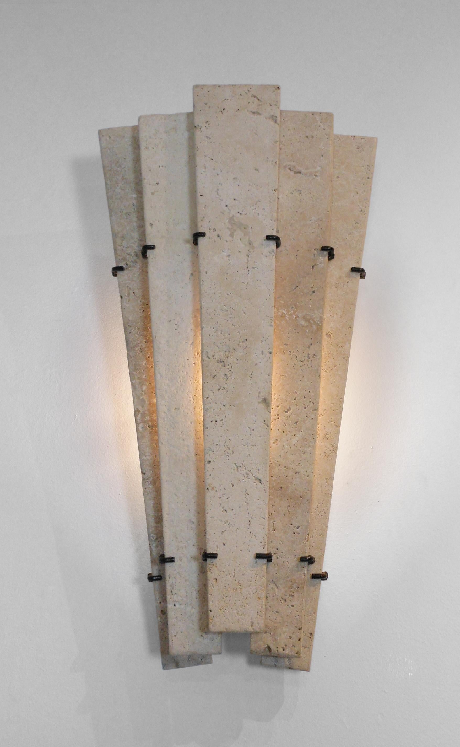 Pair French Travertine Marble Sconces
Mid Century Modern
Classic travertine innovatively used in linear strips held by metal clasps. Each composed of five tapering vertical panels arranged in a step pattern.