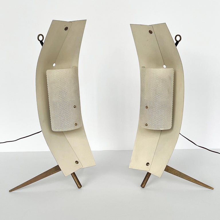 Pair of rare Modernist Italian table or wall lamps by Gastone Colliva, circa 1960s. Minimalist brass tripod base with folded brass reflector and pierced metal diffuser. Designed with a brass ring at the back to be optionally hooked on a wall as a