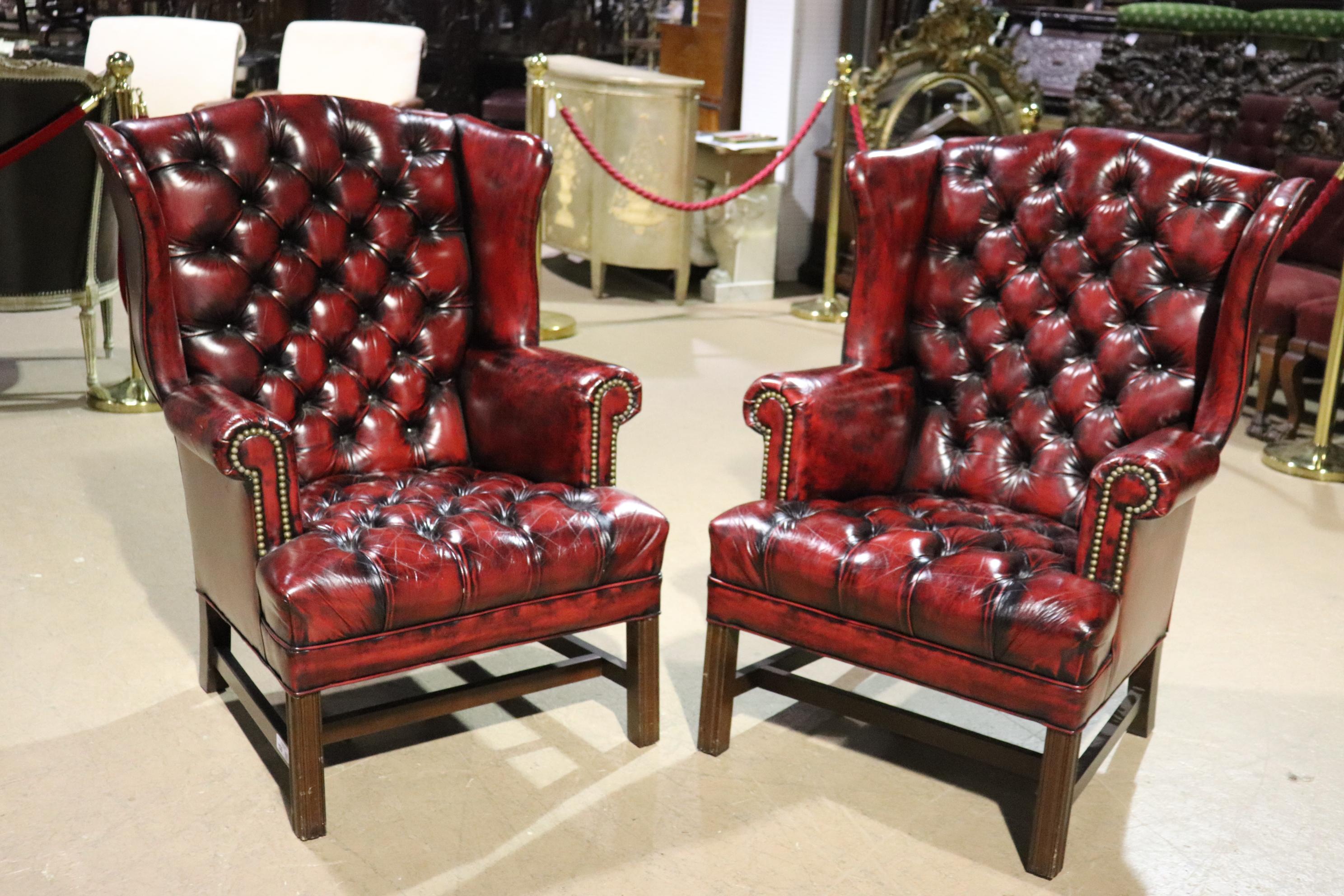 This is an absolutely gorgeous genuine top-grain oxblood leather wing chairs. Perfect for an office or any handsome livingroom setting, these vintage 1970s era solid mahogany framed wing chairs are in very good condition with no major signs of age