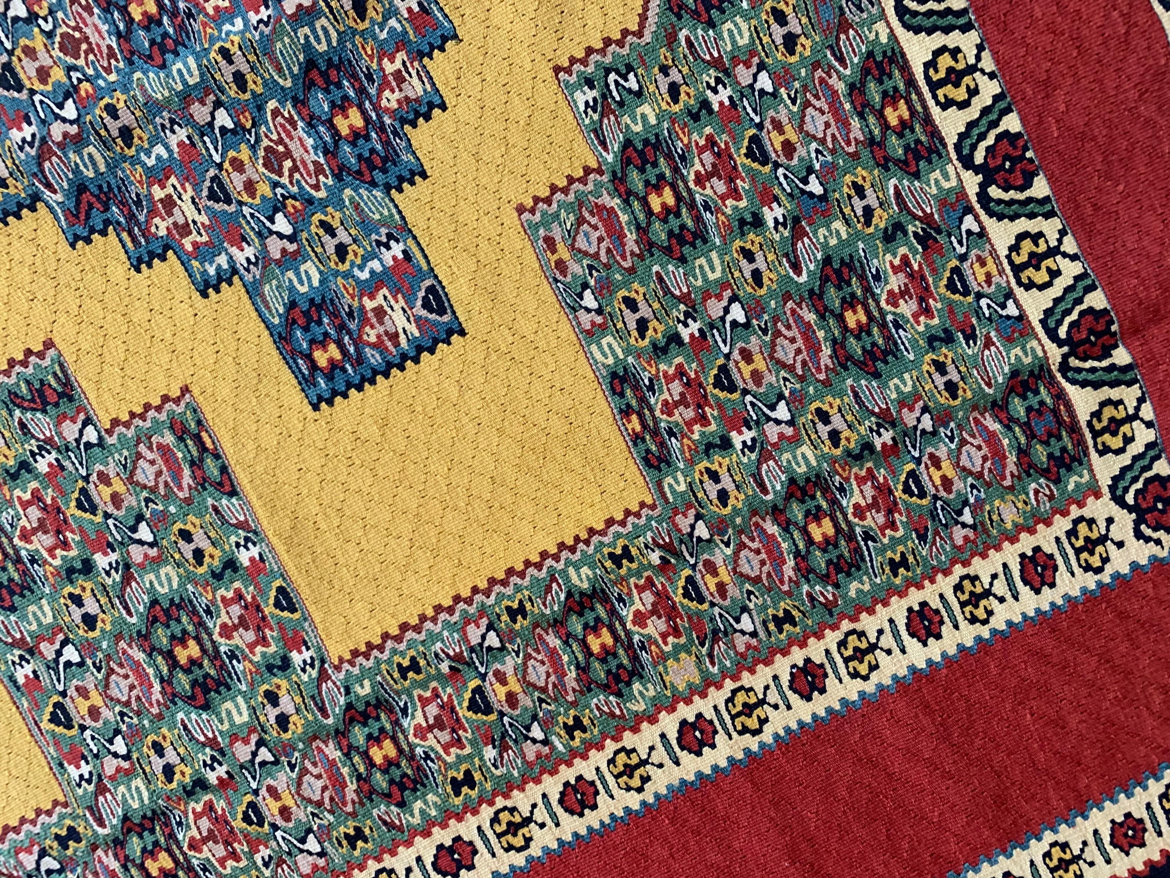 These fine wool and silk rugs are handmade flatwoven Kilim rugs, construected in the early 2000s, circa 2010. The central design has been woven on a vibrant yellow background and features a trio of medallions made up of intricate patterns in colours