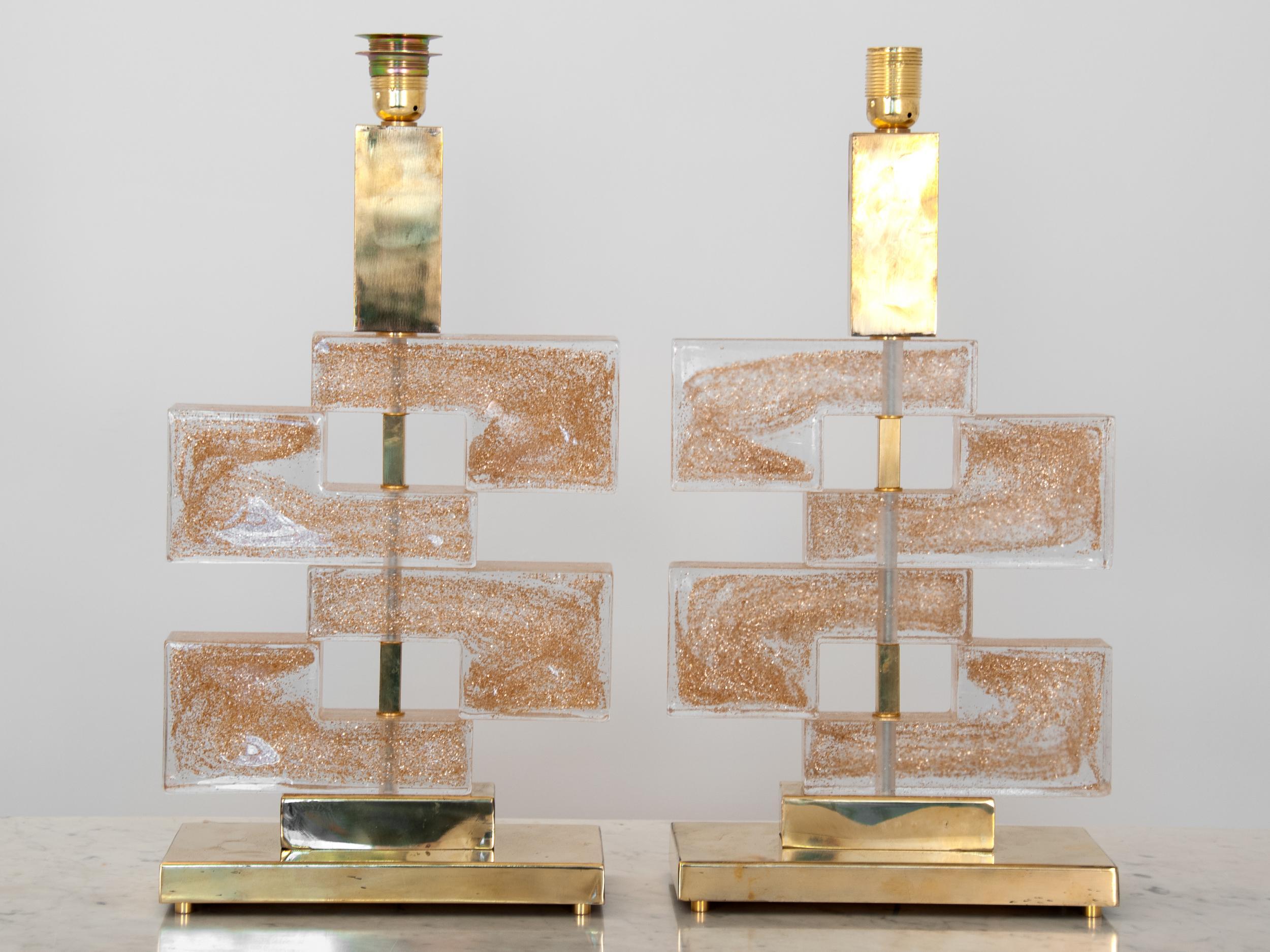 A pair of stunning Murano glass lamps with hand blown gold-flecked clear glass. The stacked geometric glass pieces marry up on a brass body creating a contemporary look with each glass shape showing their subtle handmade differences. Rewired for
