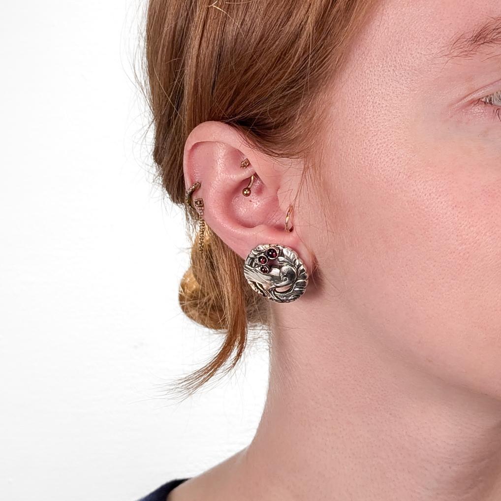 A fine pair of Danish Modern silver & garnet earrings.

By Georg Jensen.

In sterling silver.

Pattern no. 66.

Each earring with 3 bezel-set garnet cabochons.

Marked to the reverse for Georg Jensen / 925S / Denmark / 66.

The original clip backs