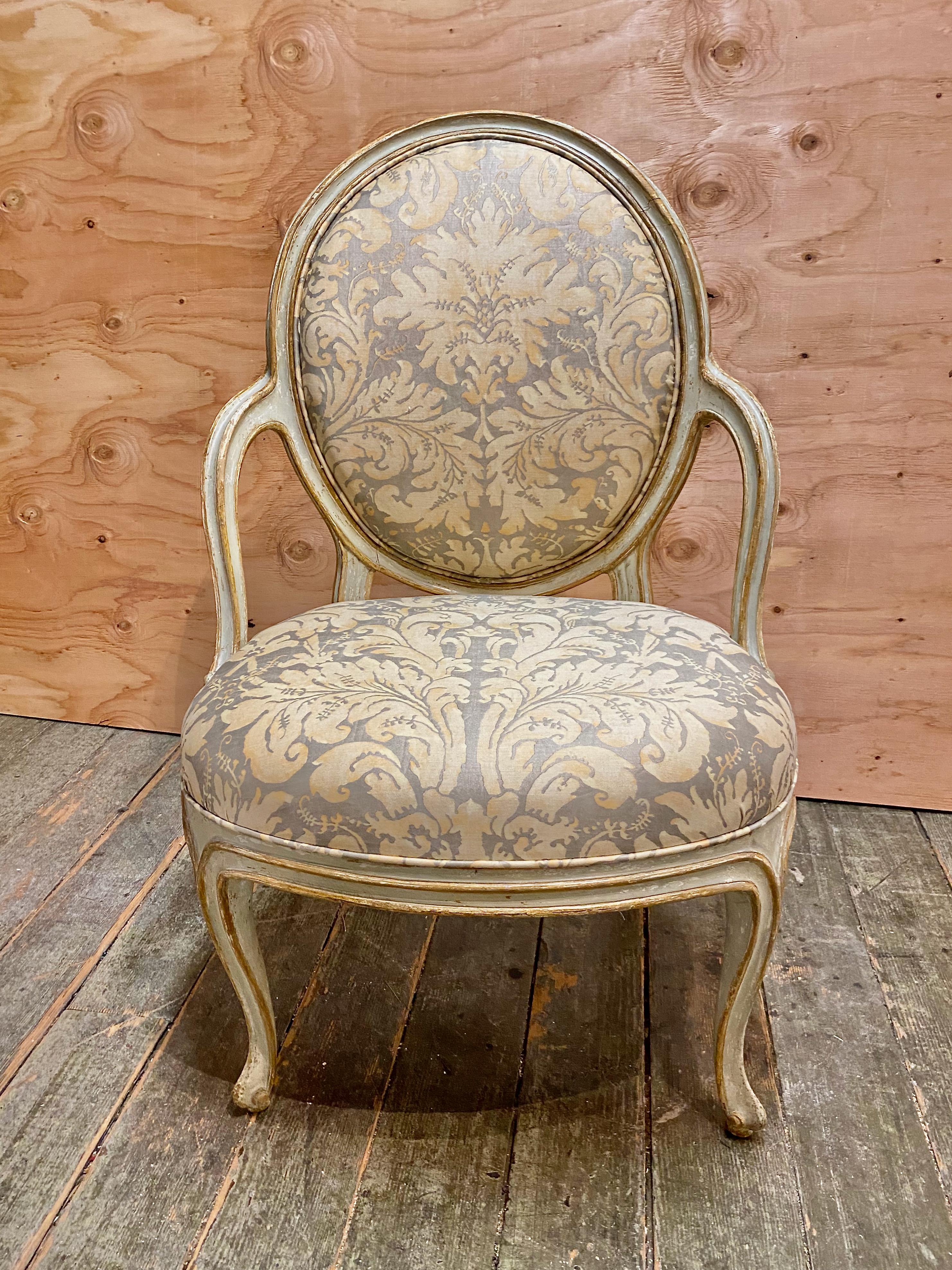 This is an exceptional pair of Adam Style George III, c. 1780 painted and gilt open arm chairs. The chairs are newly upholstered in a vintage (c.1970-1980's) Fortuny. The  vintage Fortuny has mellowed to just the right tone for the original pale