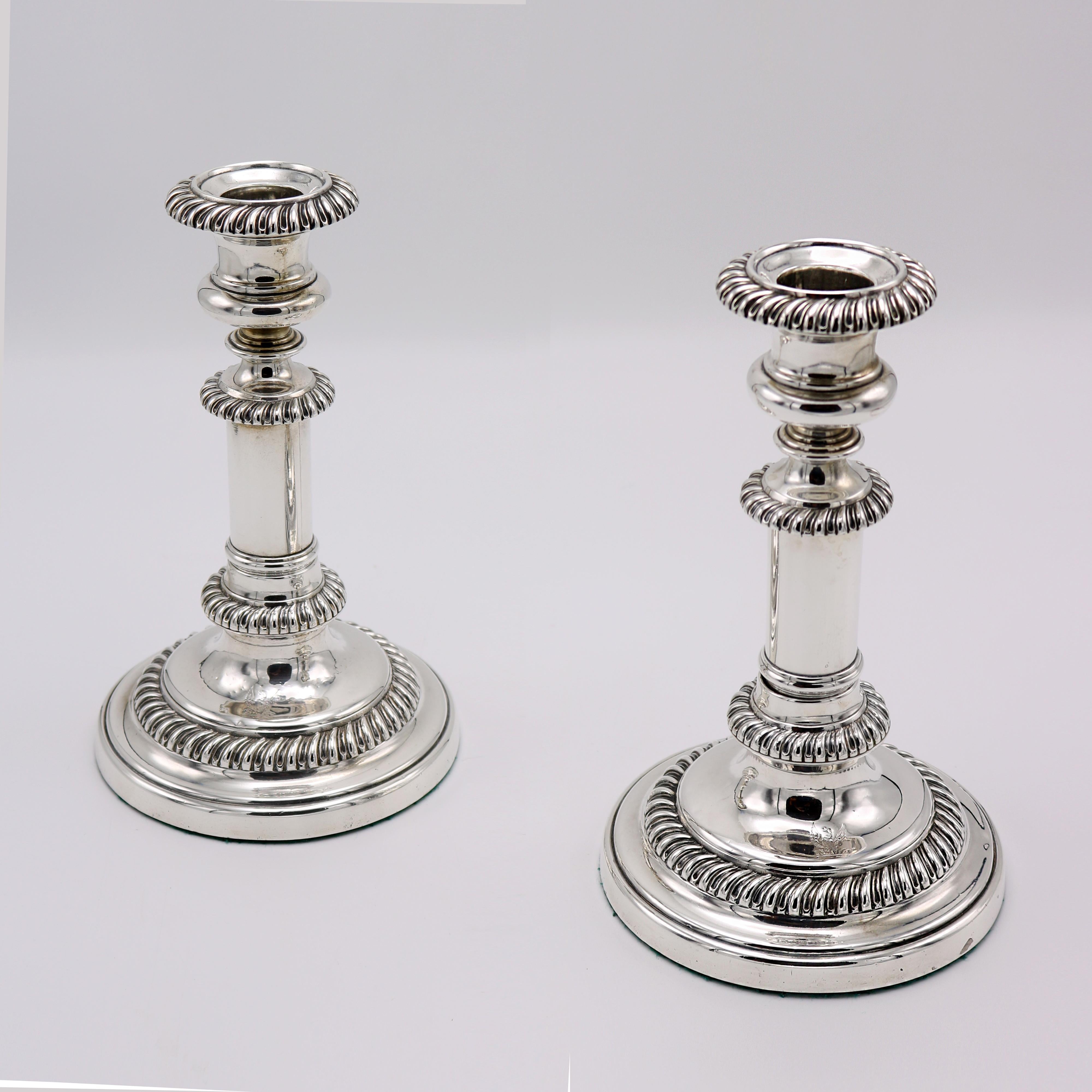 A pair of George IV period telescopic (extendable) silver plate candlesticks, marked  S.C Young and Co. from Sheffield, England circa 1825. The handsome “gadroon” pattern encircling the bobeche on each stick is repeated on each descending level