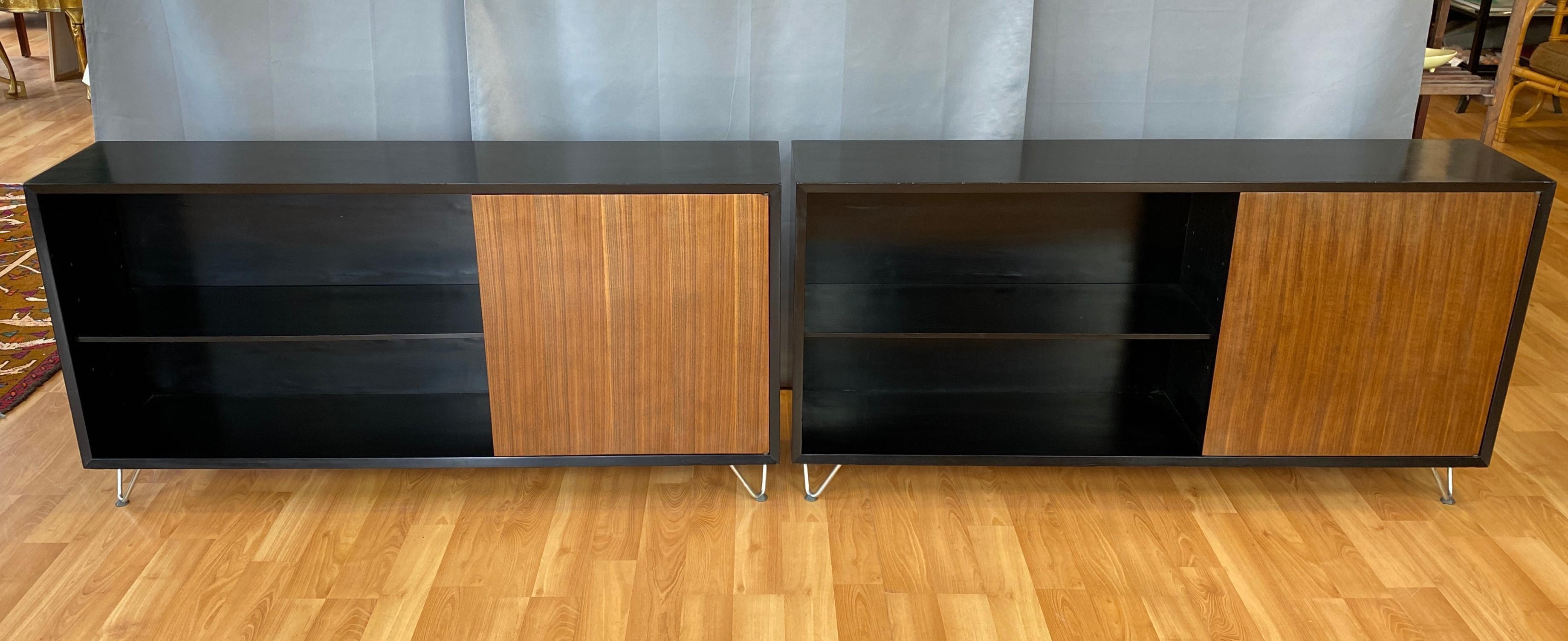 A pair George Nelson designed Black bookcases with Walnut doors for Herman Miller.

Each shallow unit has one adjustable shelf, and small cabinet with a Walnut door. Behind the doors
is a adjustable shelf in each one. Herman Miller labels inside