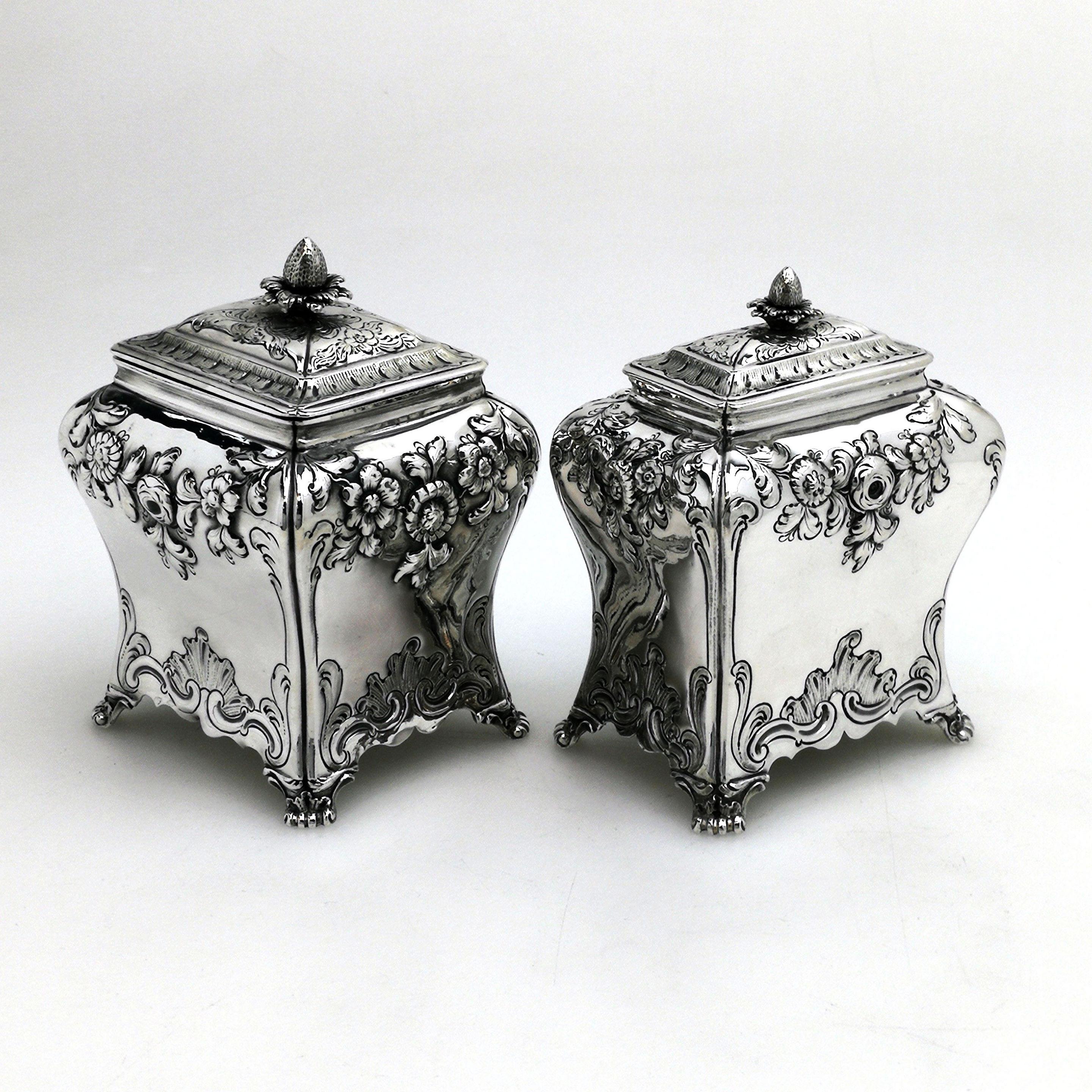 A Pair of lovely sntique Georgian solid silver graduated Tea Caddies. These rectangular Tea Caddies have beautiful chased floral swags on the upper shoulders and each stands on four feet. The Caddies are of graduates size - both the same width but